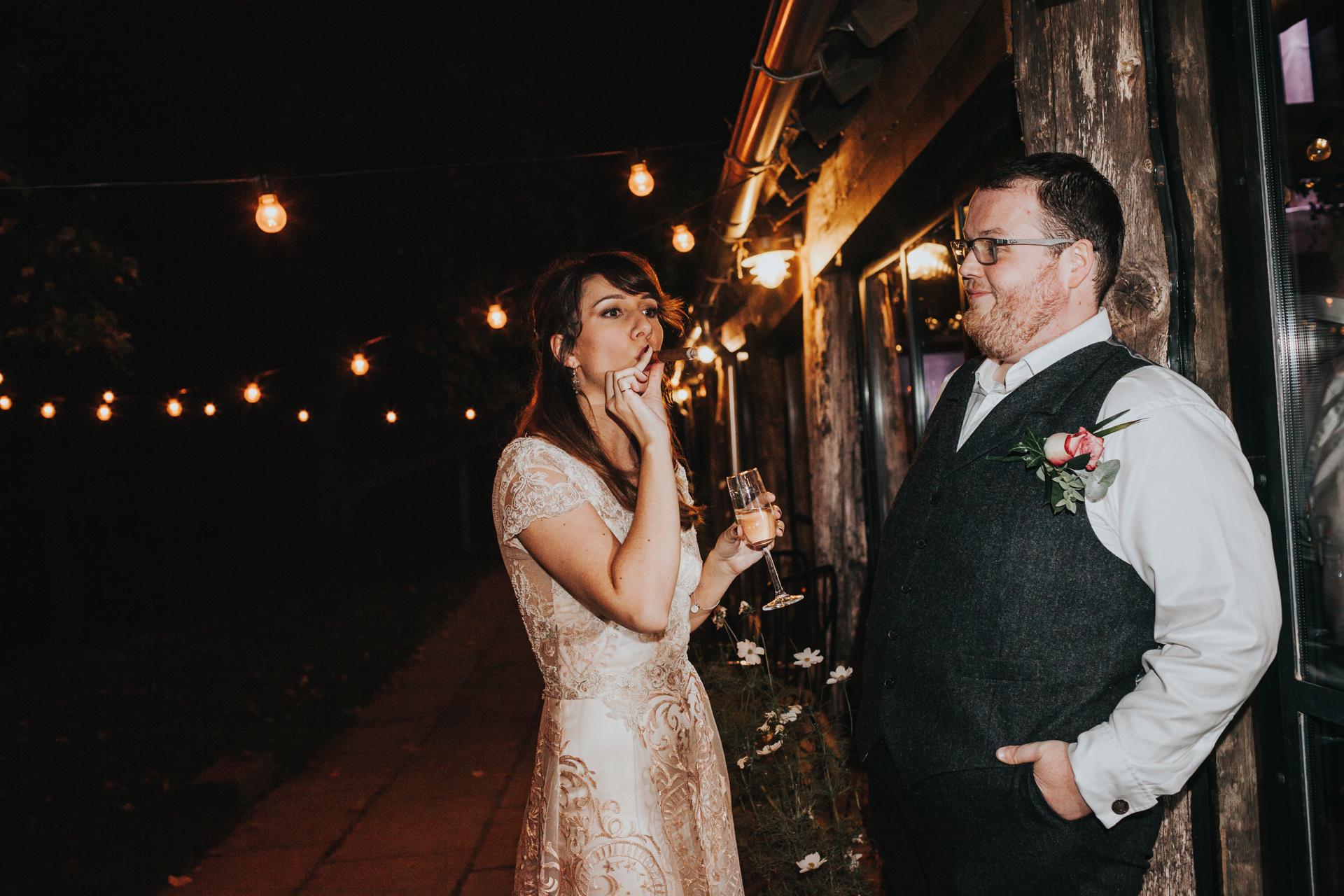 Bride and groom share a cigar. 