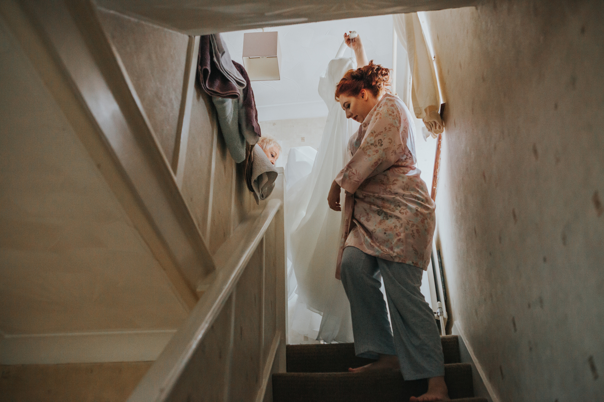 Bride bringing her dress down the stairs. 