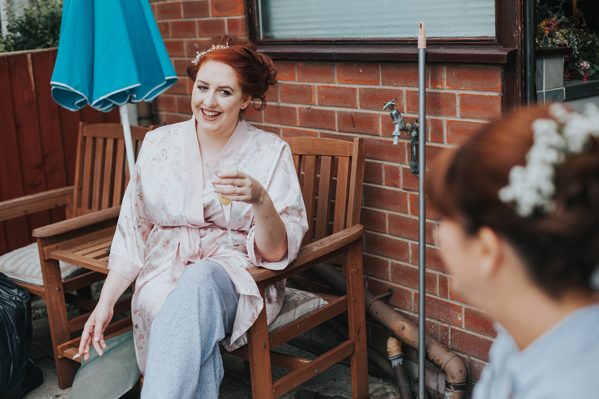 Bride having a fag and bucks fizz break in the kitchen. 