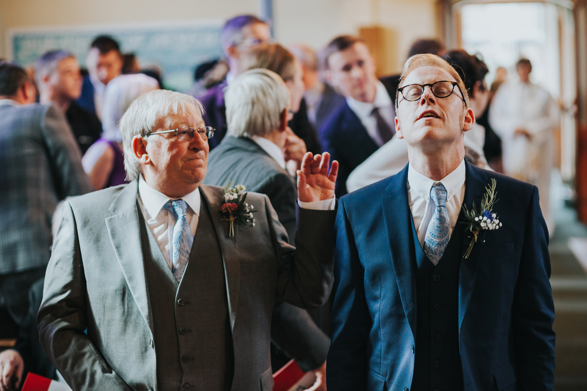 Grooms Dad comforts groom as he stands at the end of the aisle waiting for bride. 