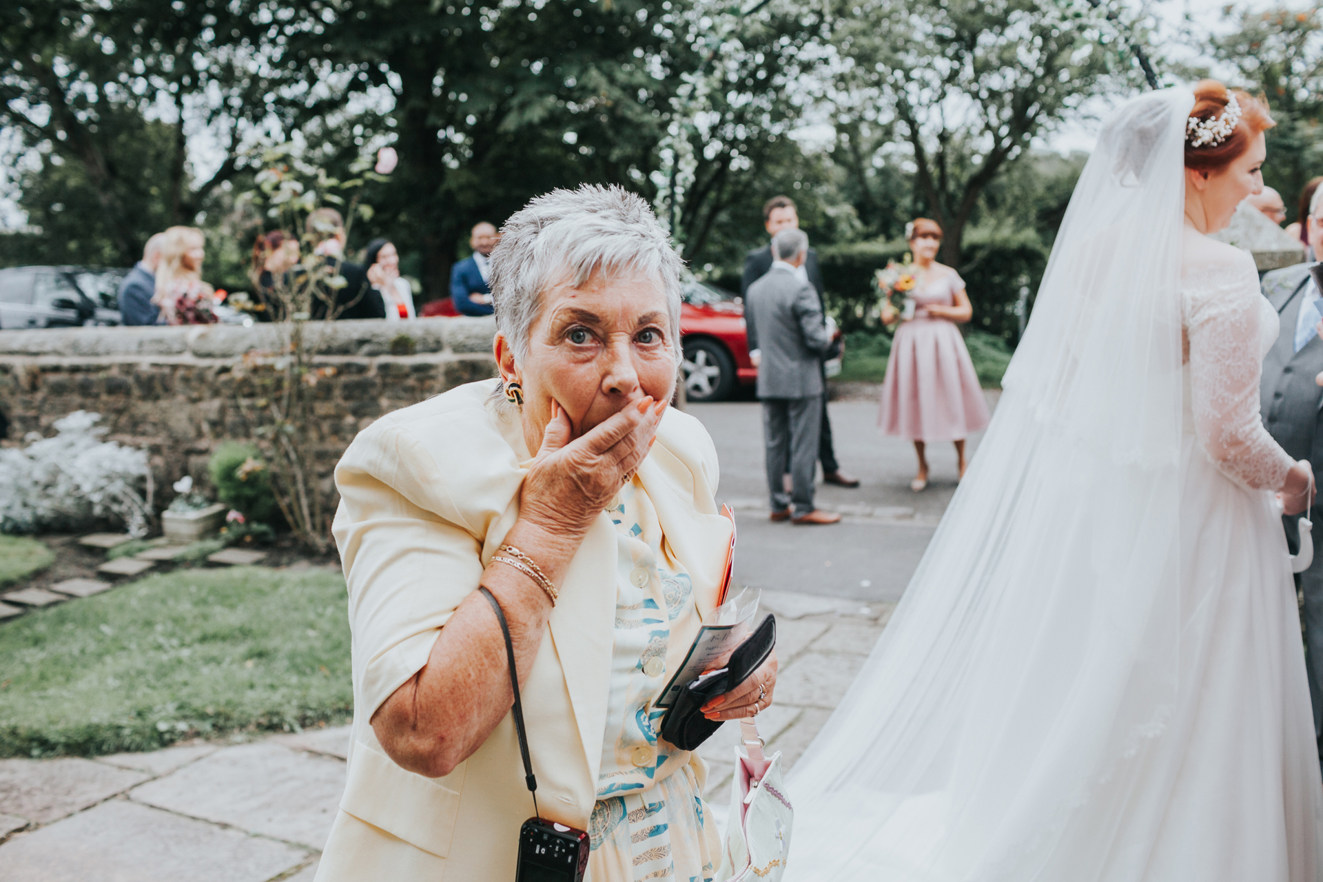 Wedding Guest with hand over her face looking guilty.