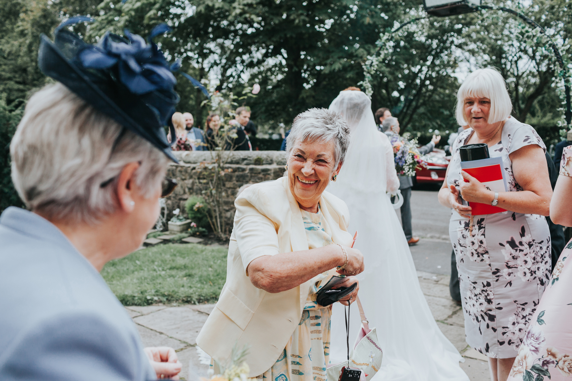 Wedding guests get ready with confetti. 