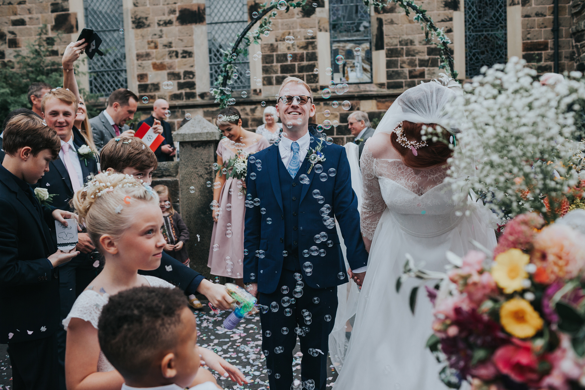 Bubbles, flowers and bride and groom as they exit St Thomas's Church, Liverpool.