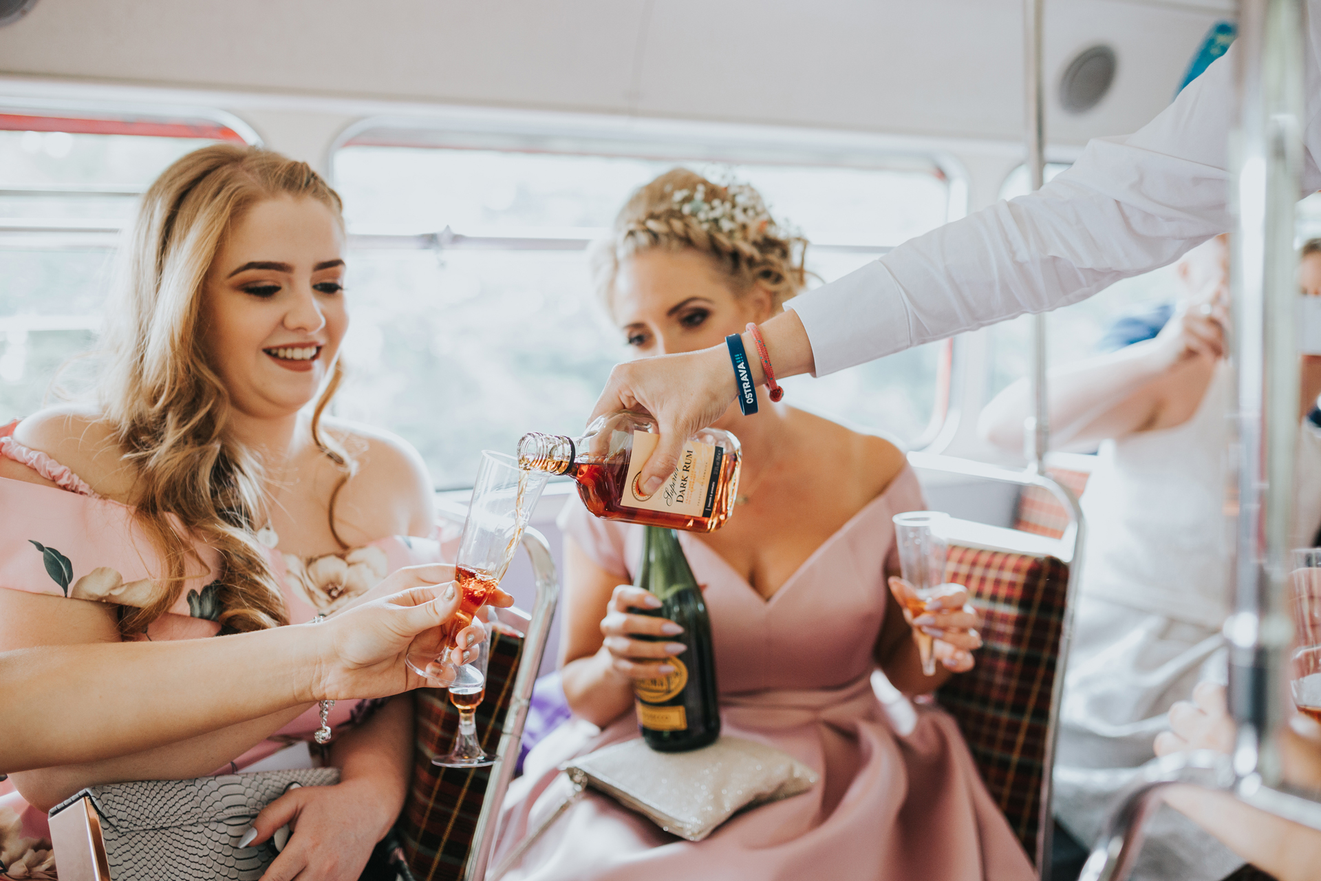 Guests pour some hard liquor on the top deck of the wedding bus.