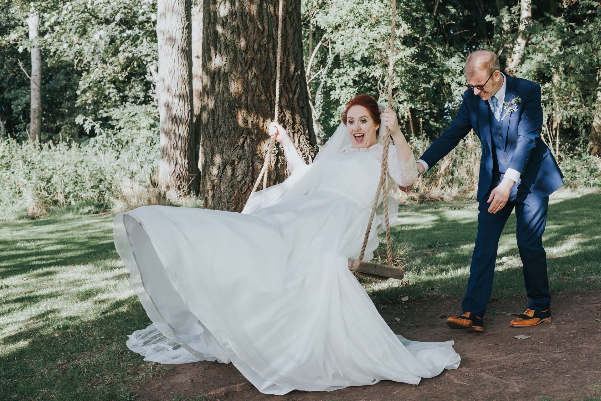 Bride and groom playing on swings. 