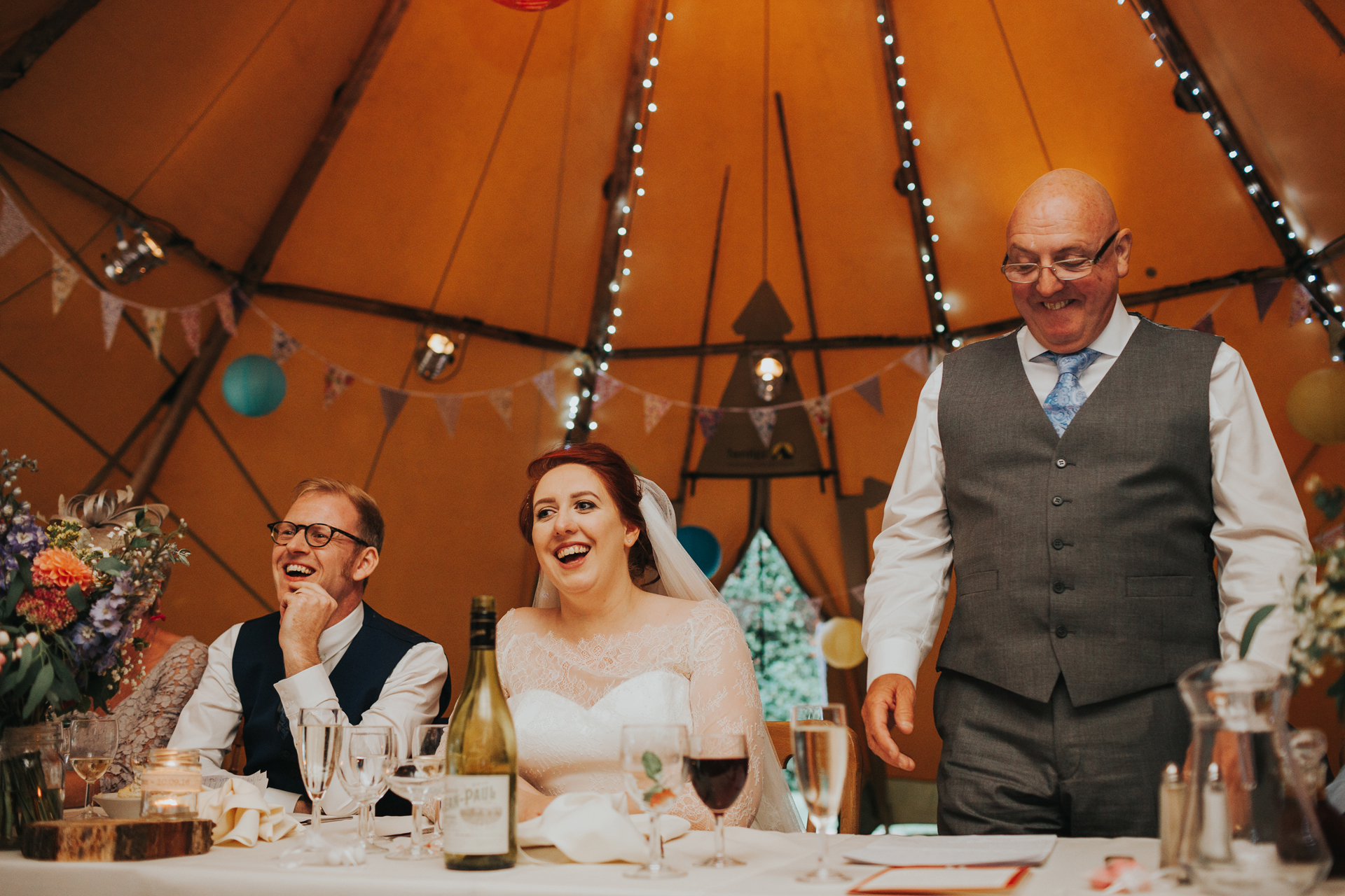 Bride and Groom laugh at the father of the brides speech. 