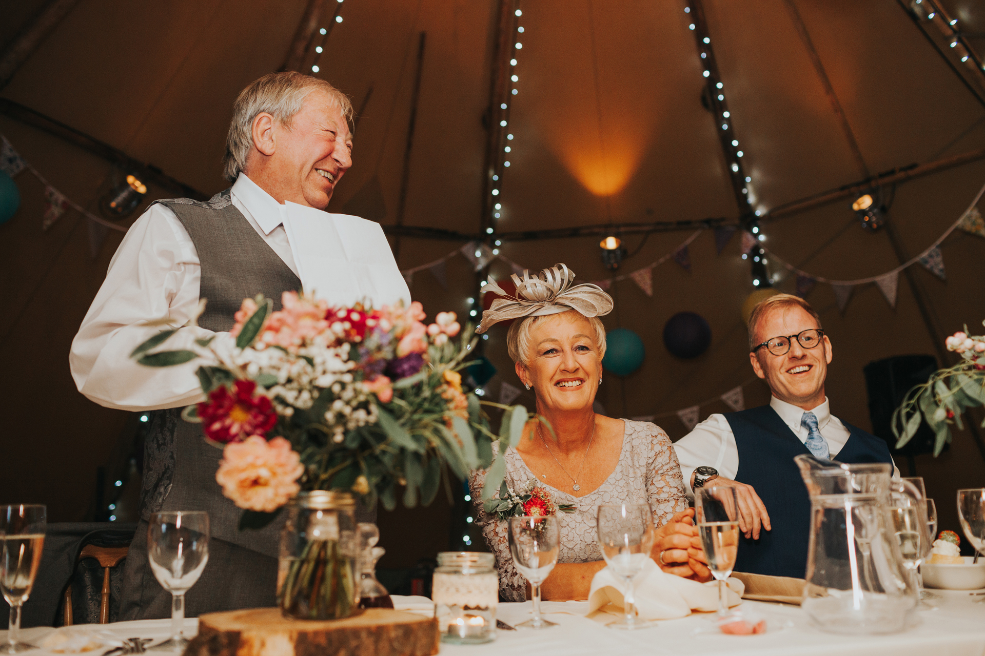 Mother of the bride and groom laugh at speech. 