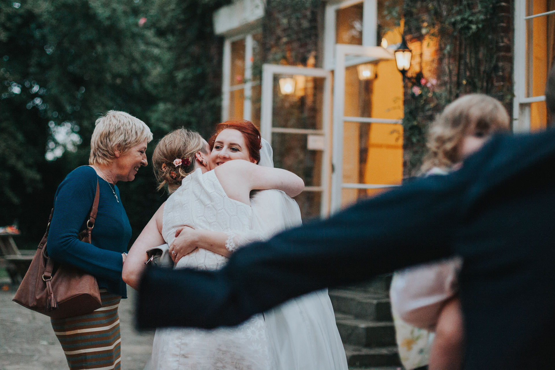 Bride hugging a guest outside the tipi. 