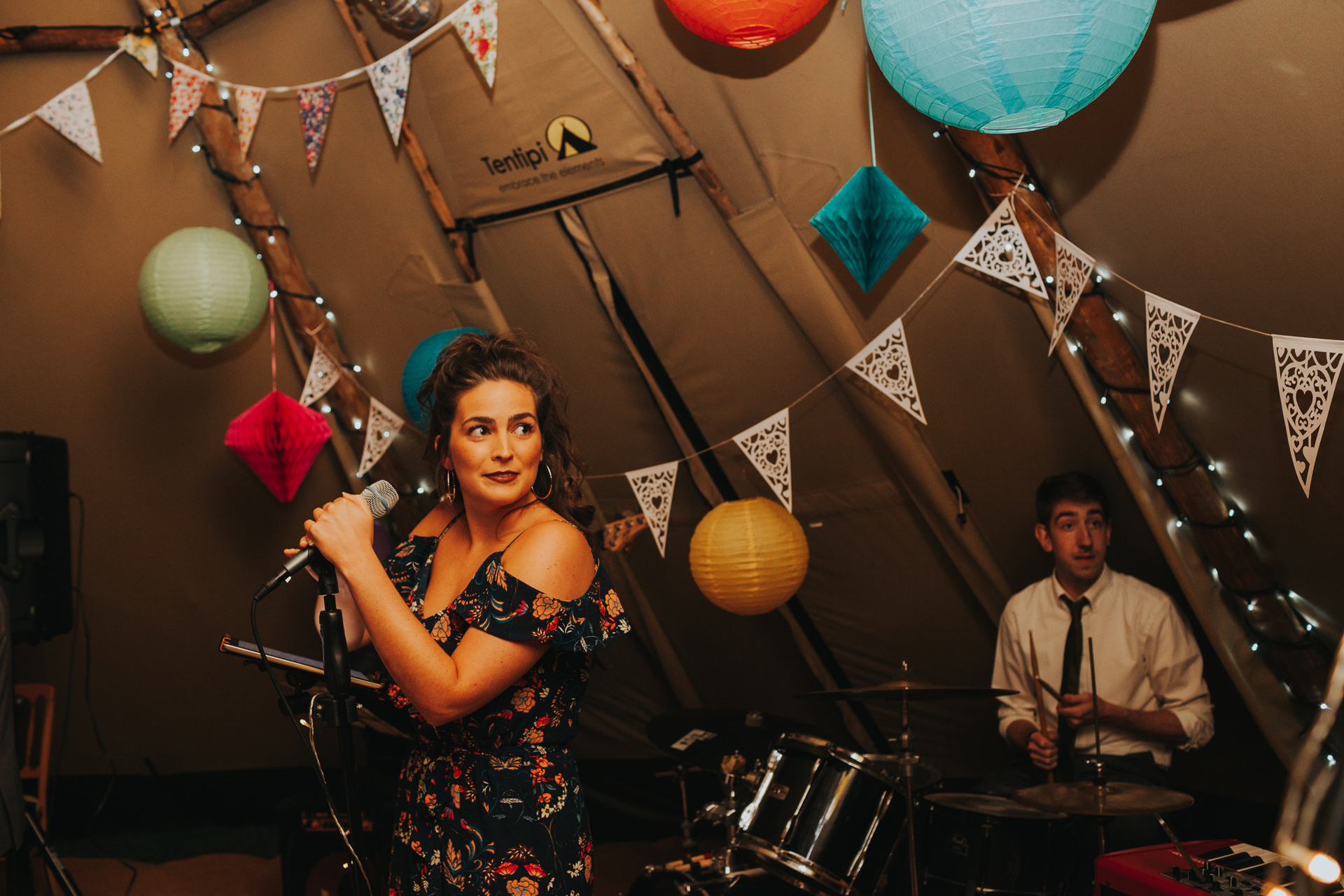 Singer in band performs in tipi. 