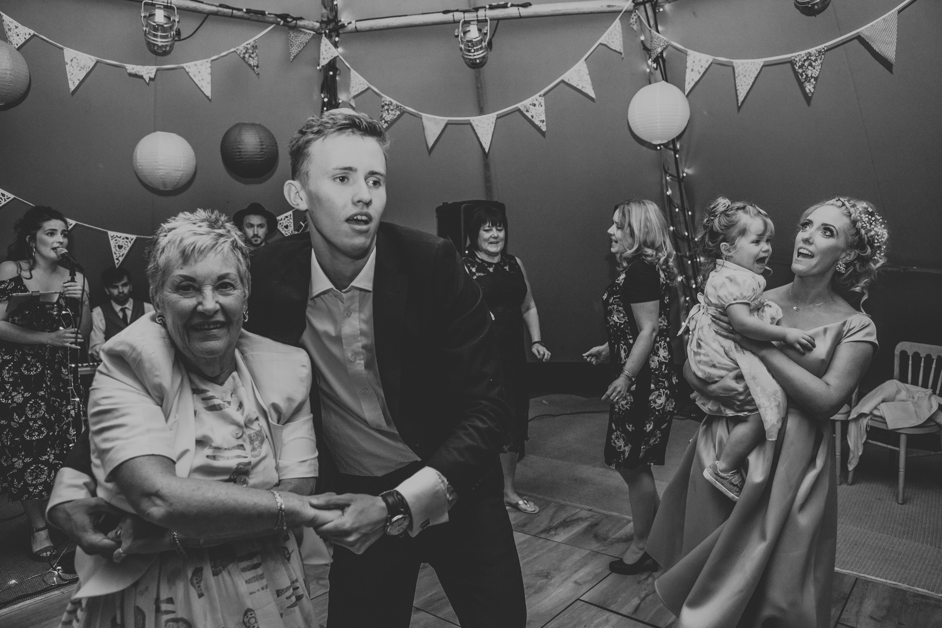 Guests dancing in tipi. Photo in black and white. 