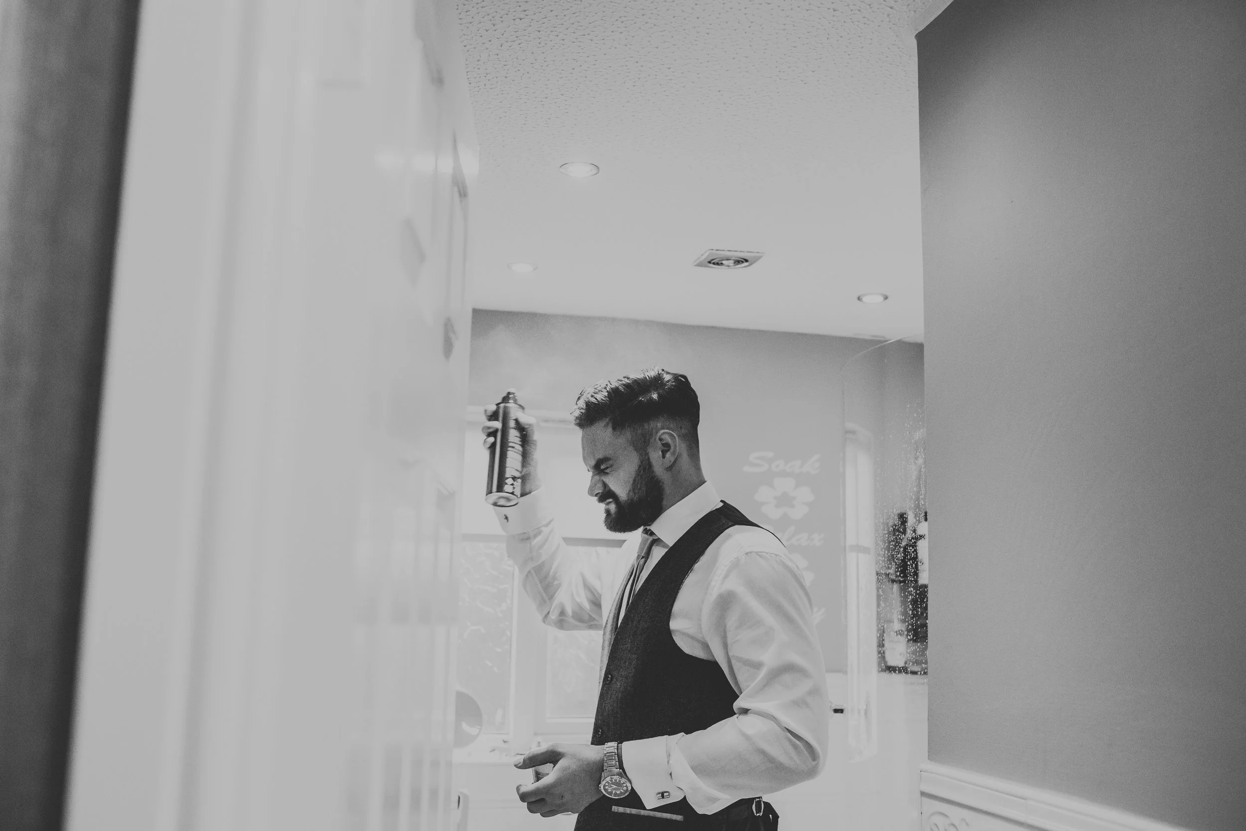 Groomsmen putting on hair spray. 