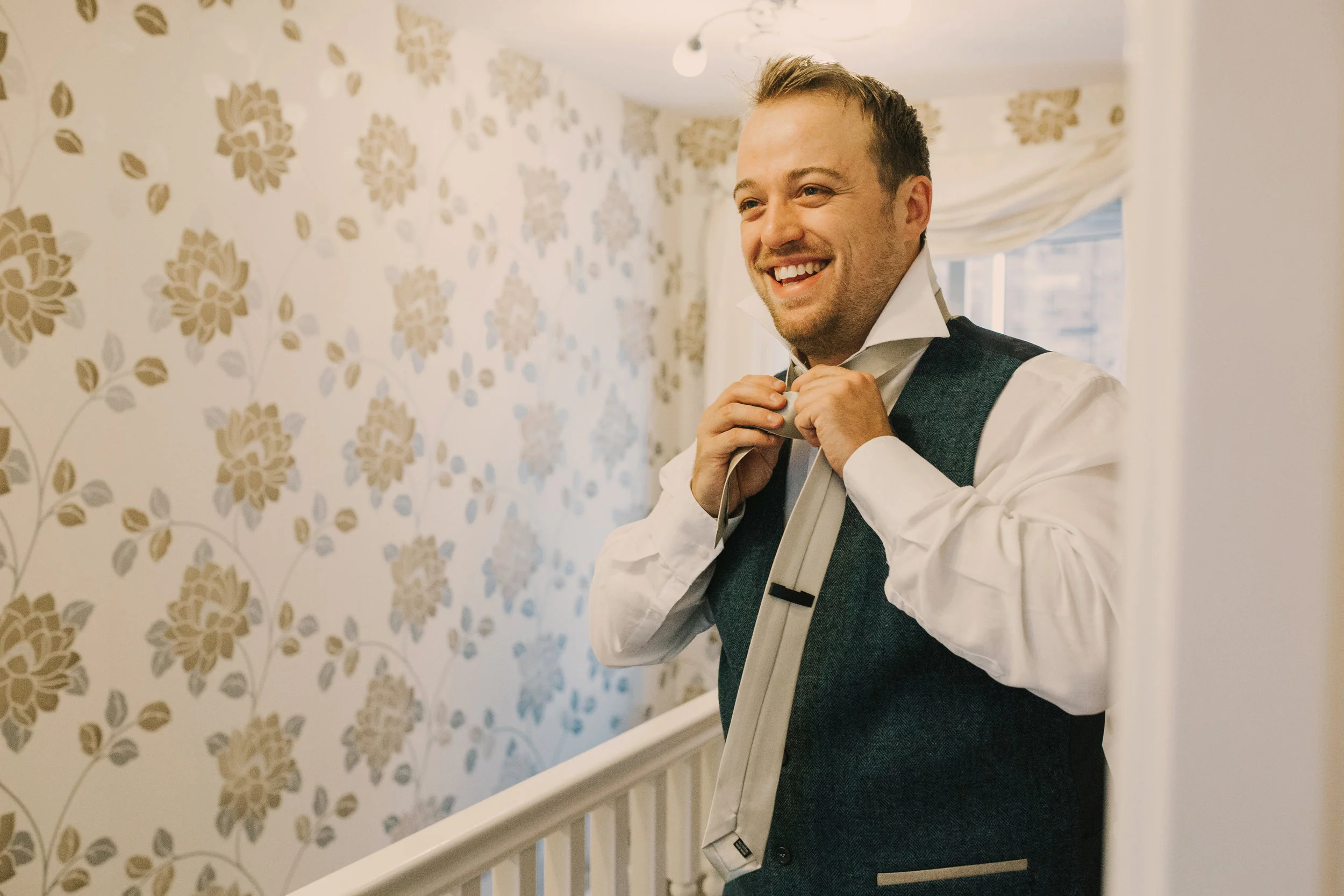 Groomsman putting on tie. 