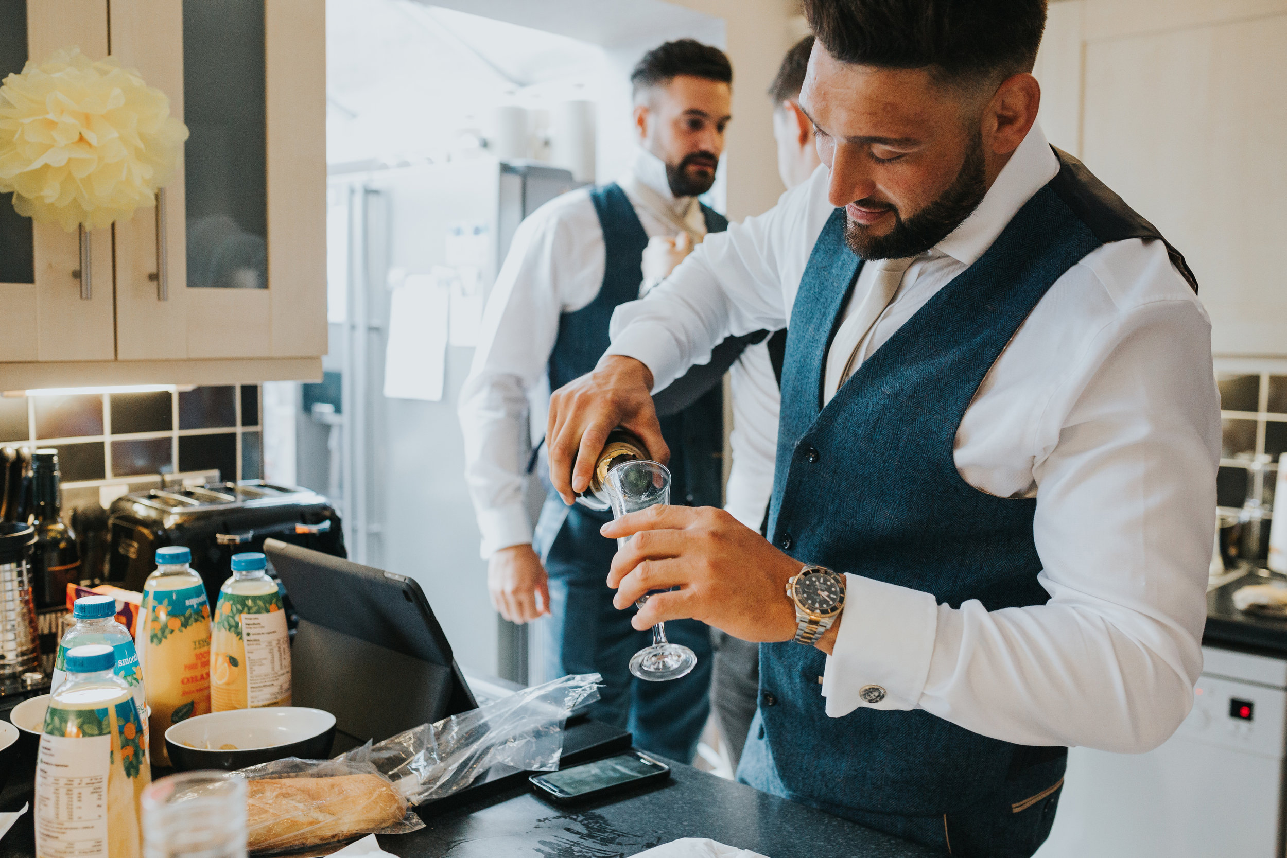 Groomsman pouring a drink.