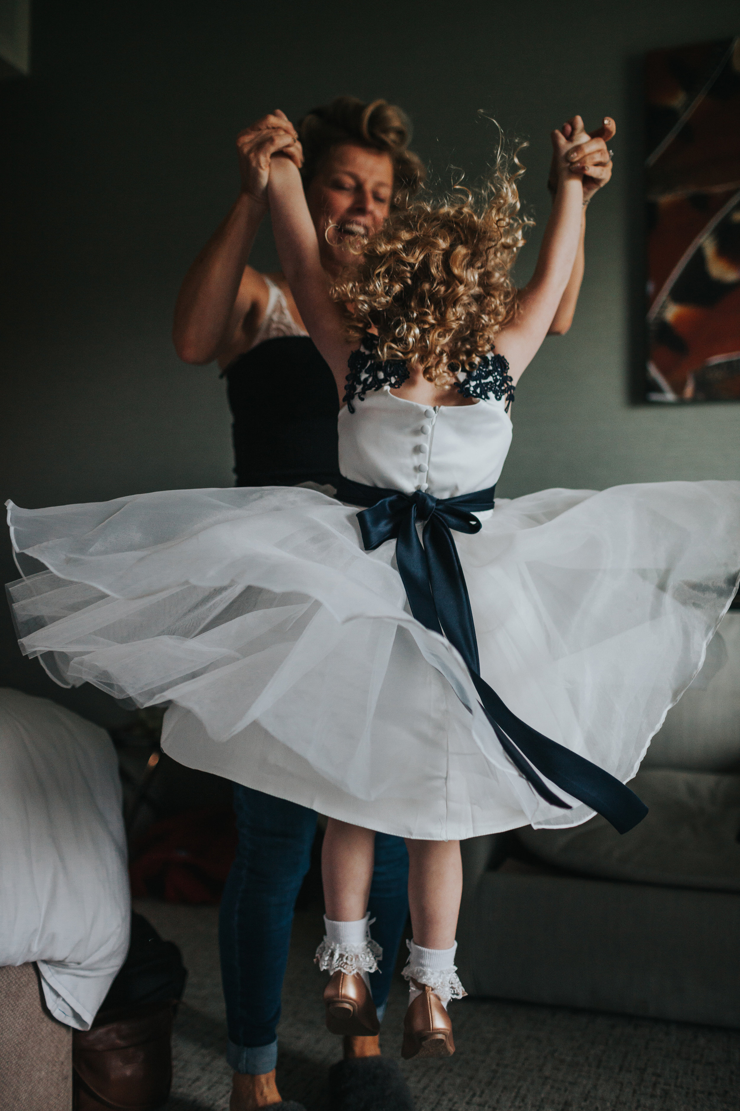 Flower girl jumping with Mother of the bride.