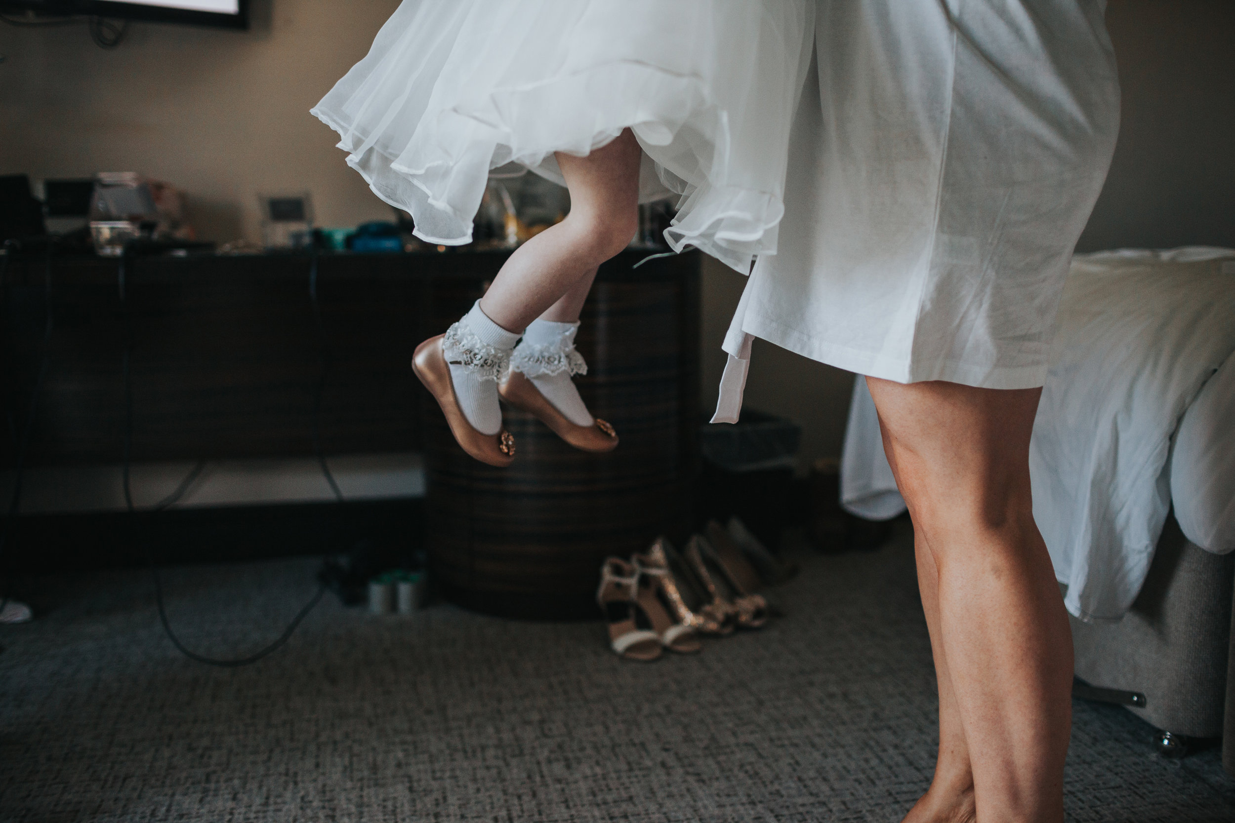 Close up of flower girls feet in the air. 