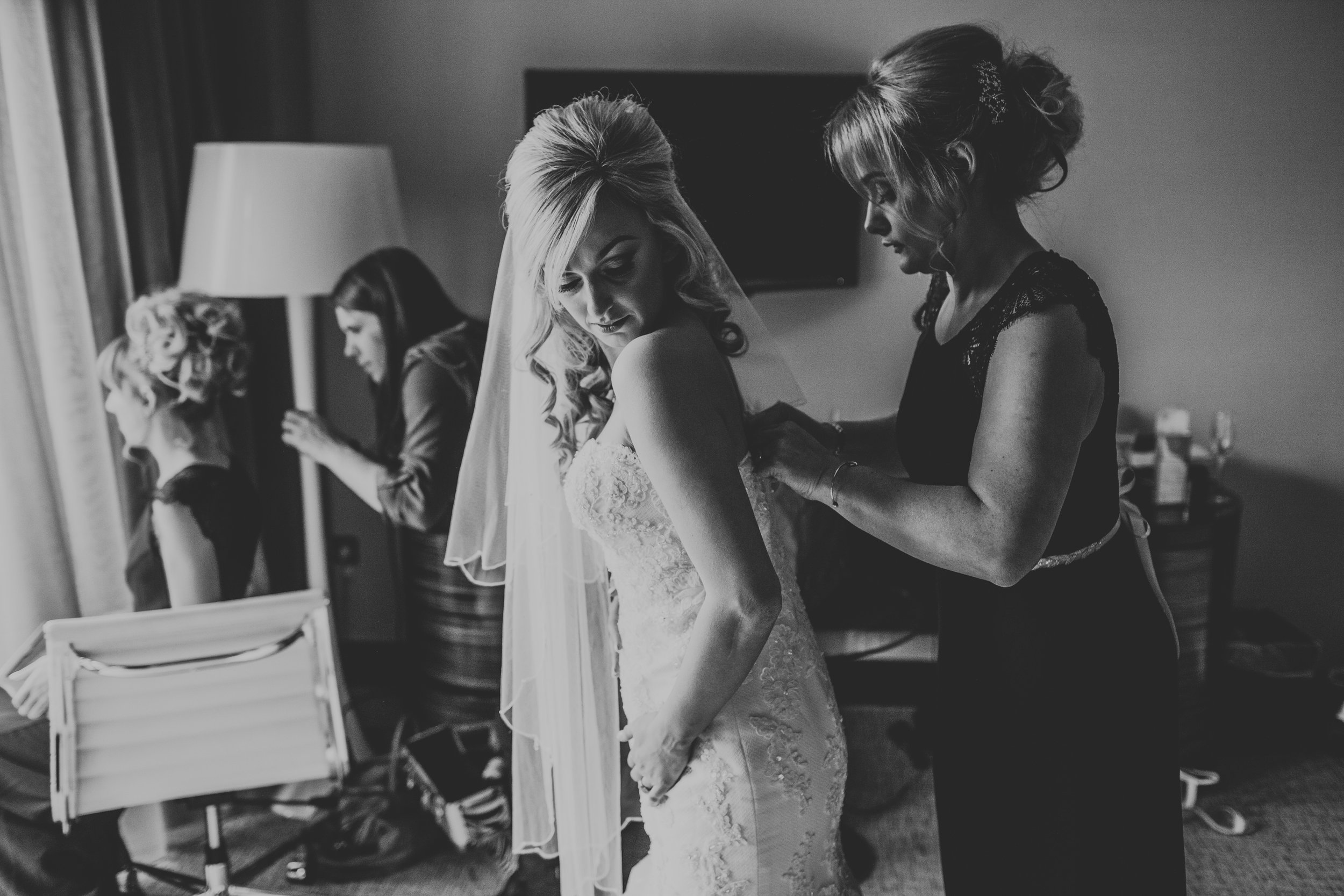 Bride getting her dress put on. 
