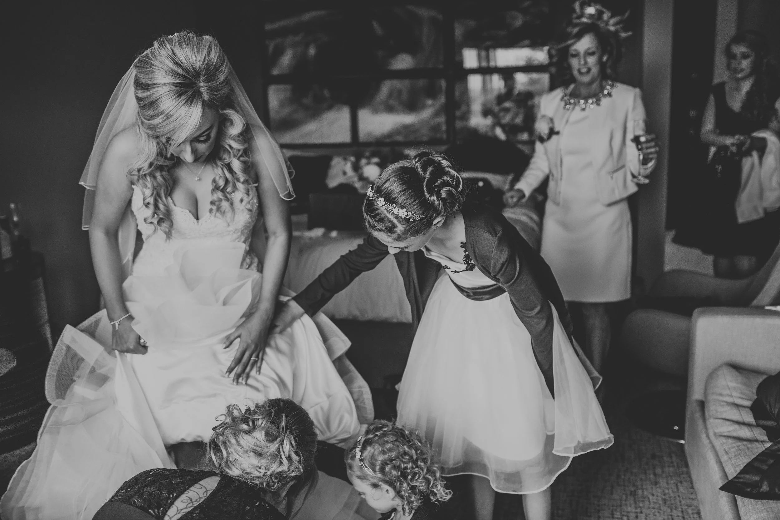 Bride getting ready with her flower girls helping her. 
