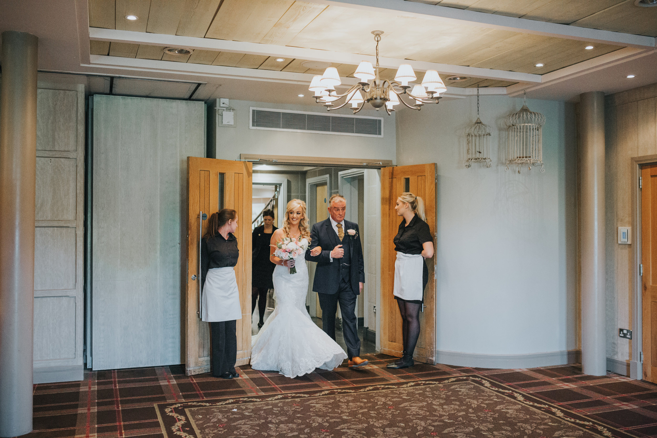 Bride and the father of the bride enter the ceremony room. 