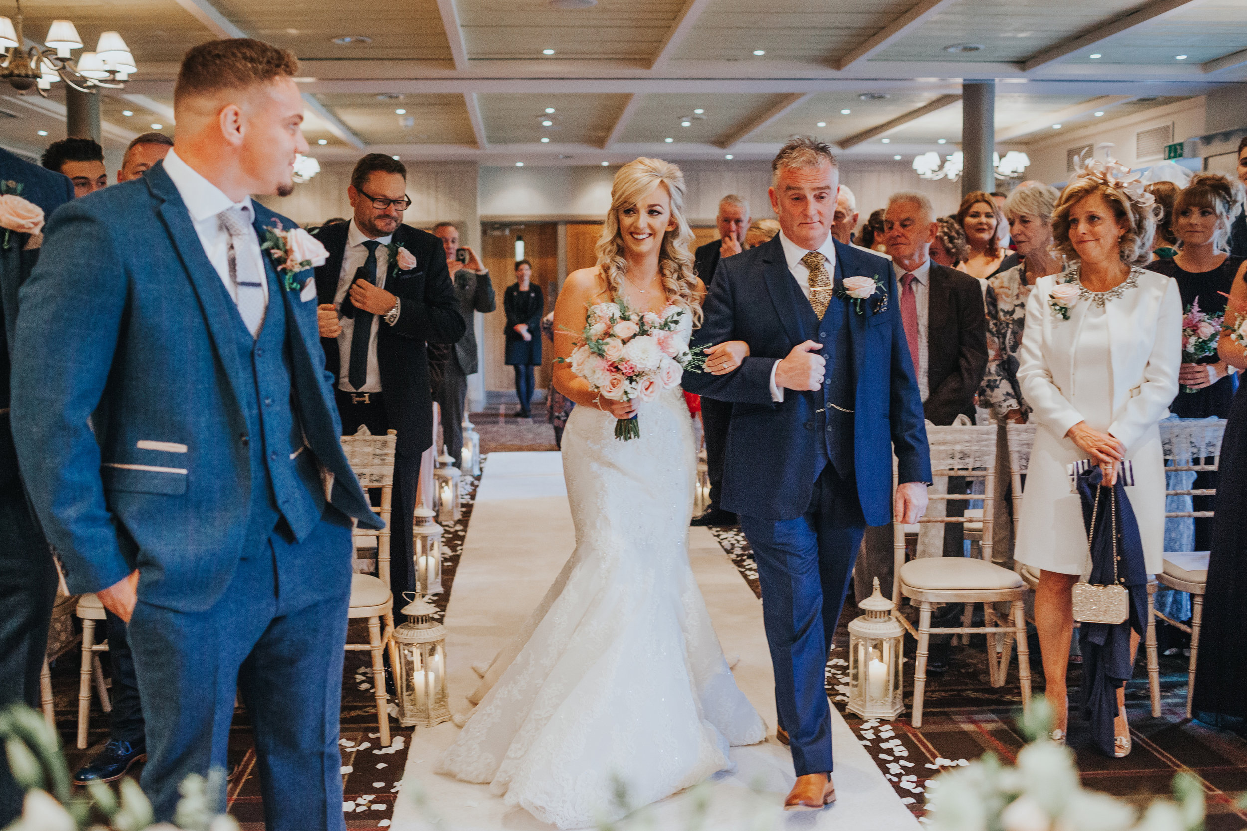 Bride walks down the aisle with her father. 