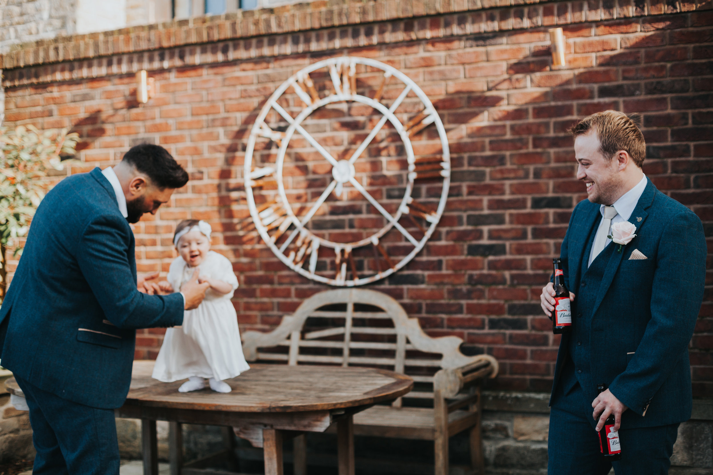 Little girl plays with the groomsmen. 