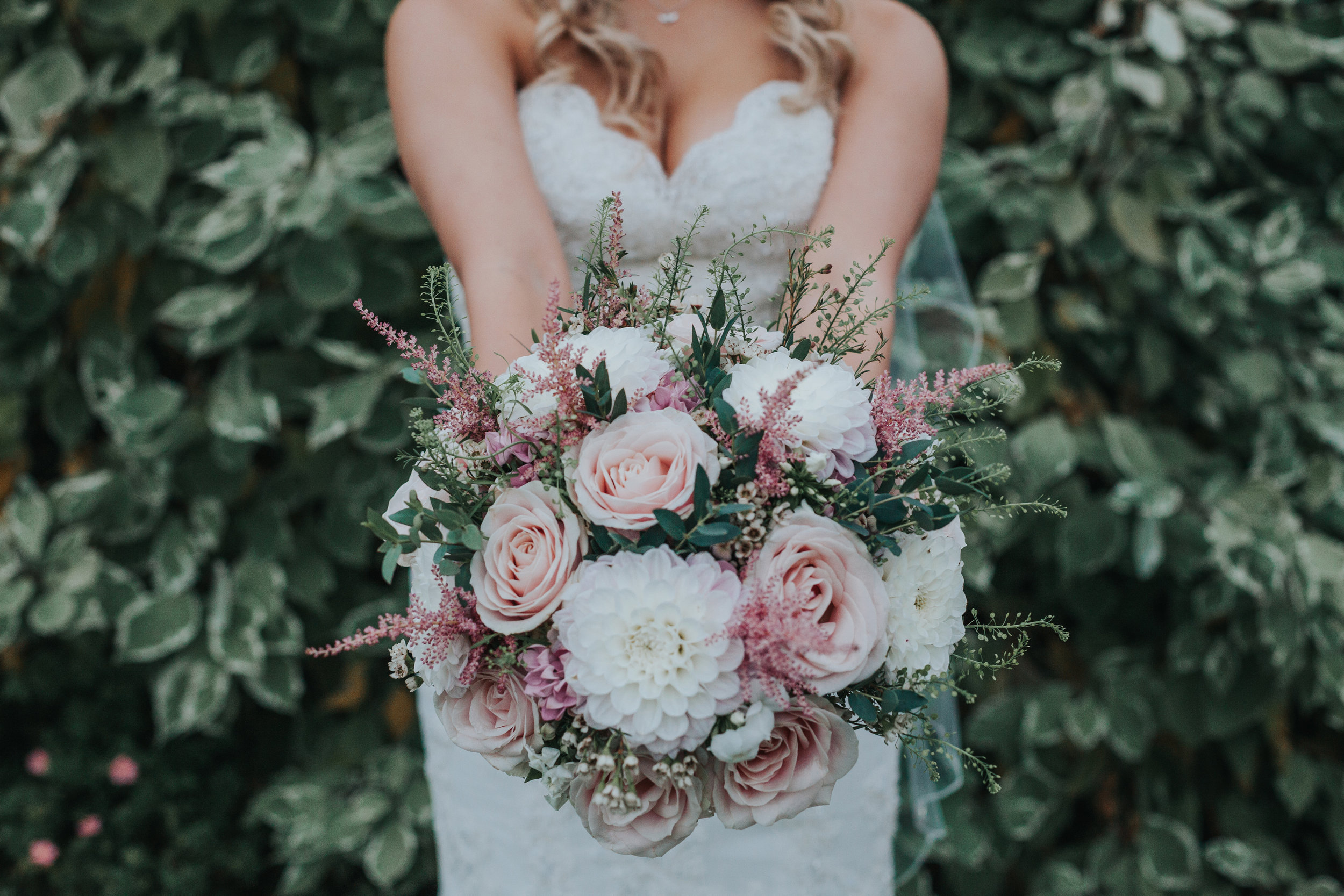 Bride poses with flowers. 