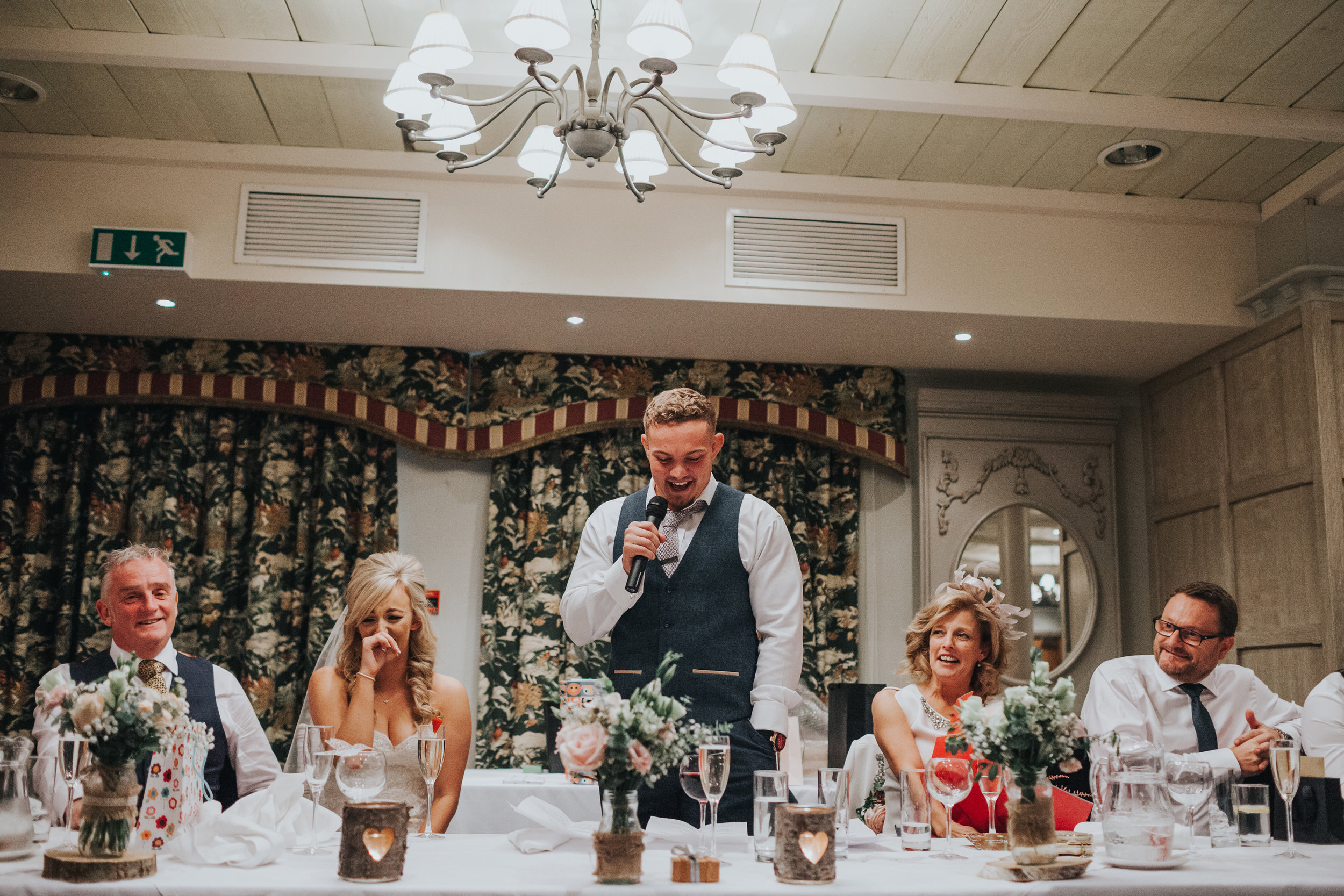 Head table laughs as the groom makes his speech. 