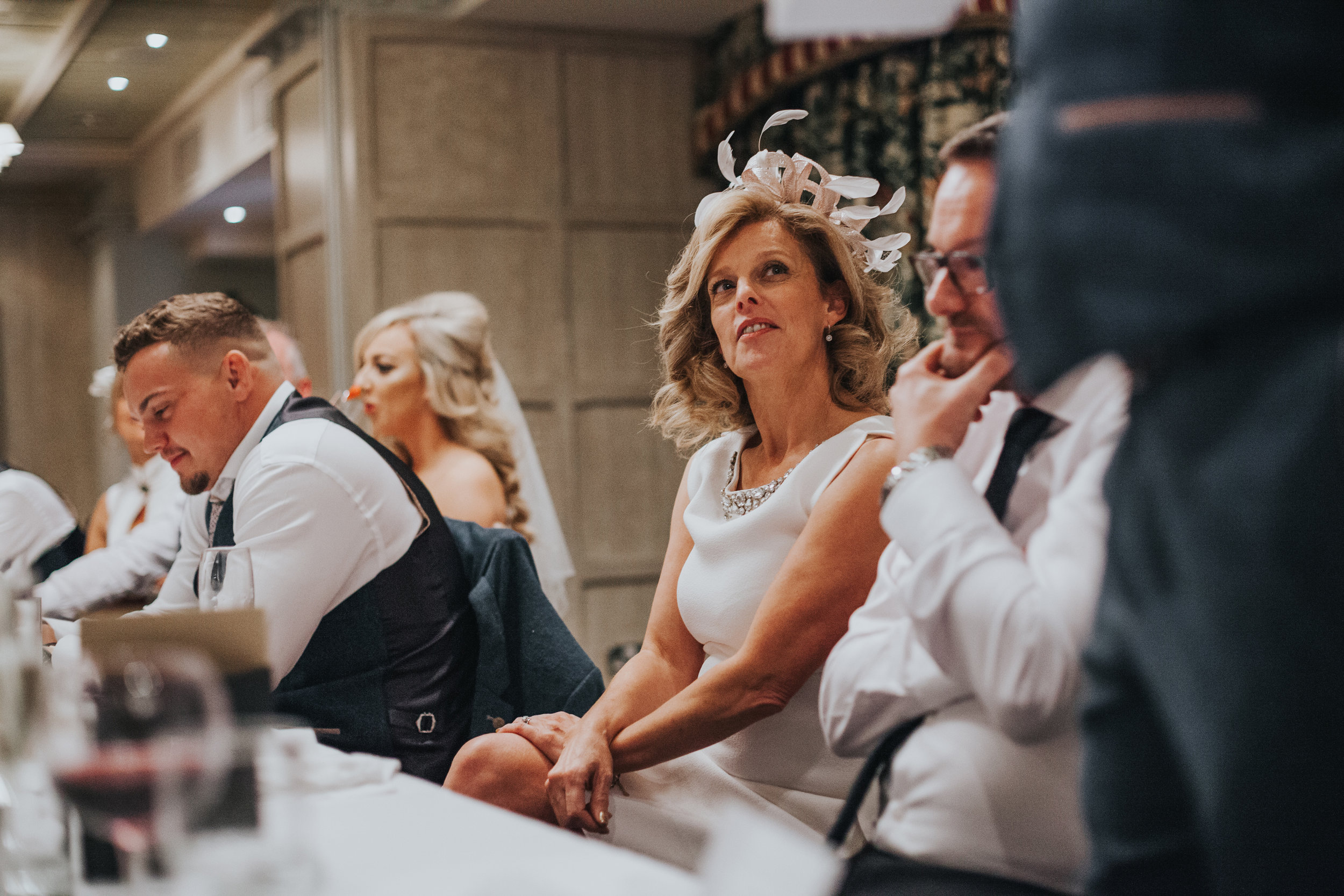 Mother of the bride smiles listening to best mans speech. 