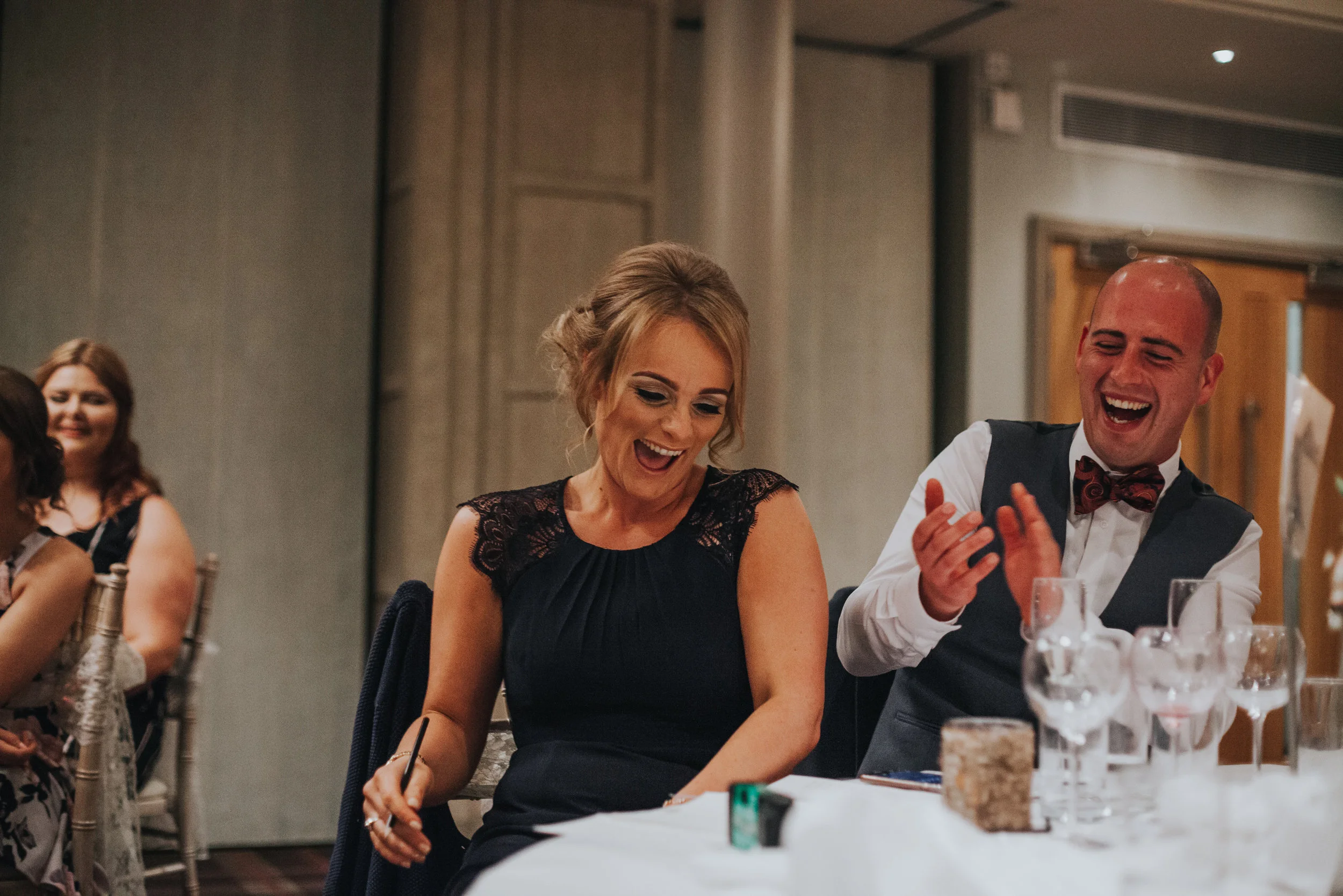 Couple laughing at speeches. 