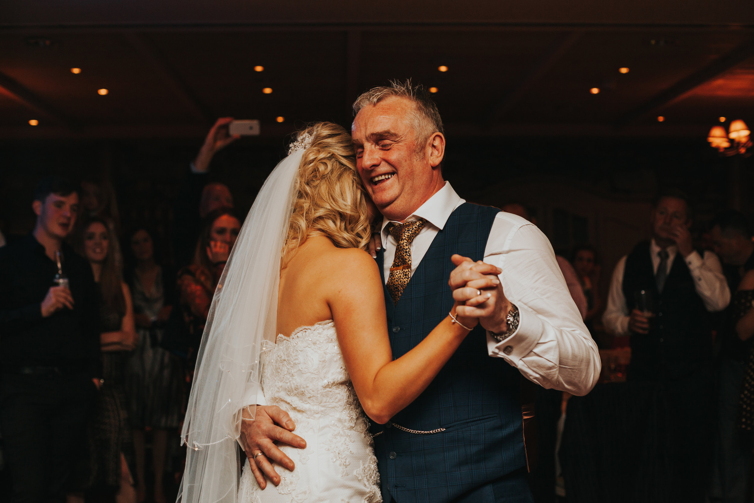 Dad laughing as he dances with his daughter.