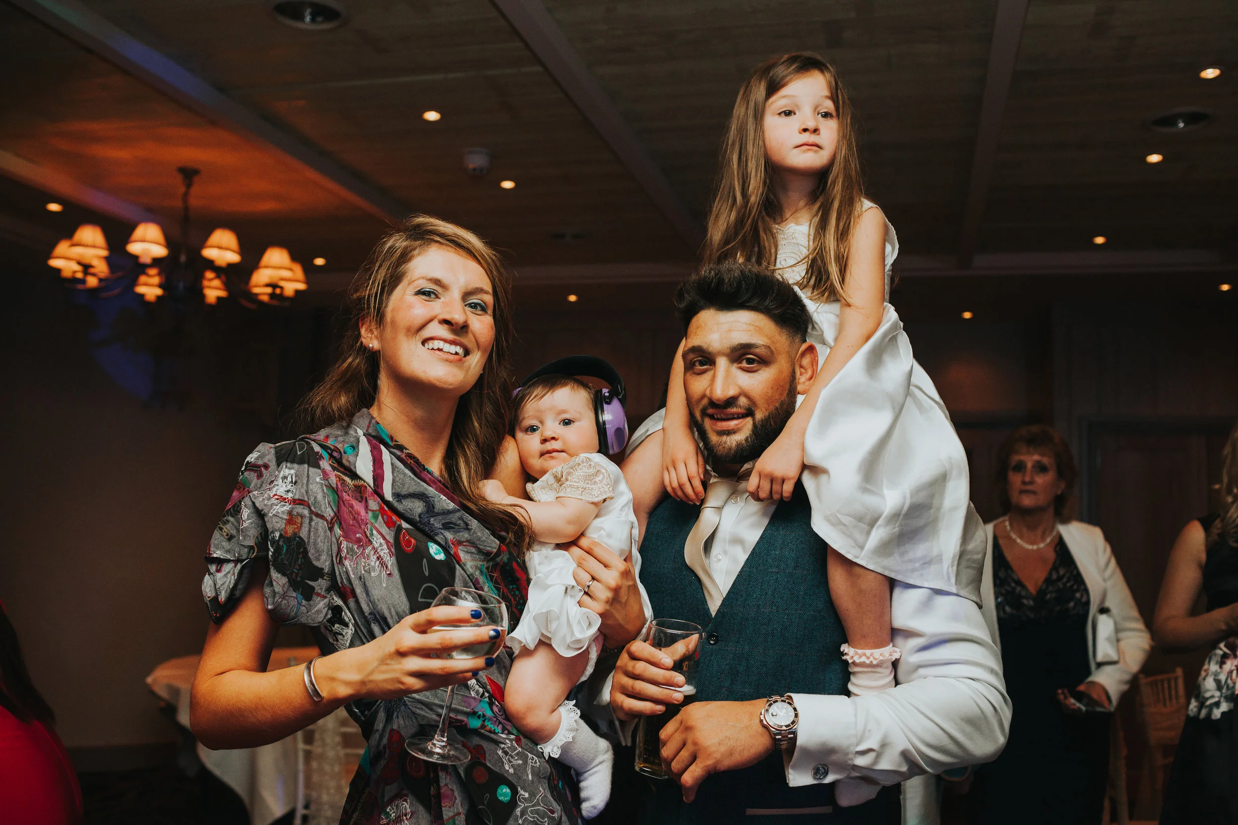Family posing on dance floor at Stanley House. 