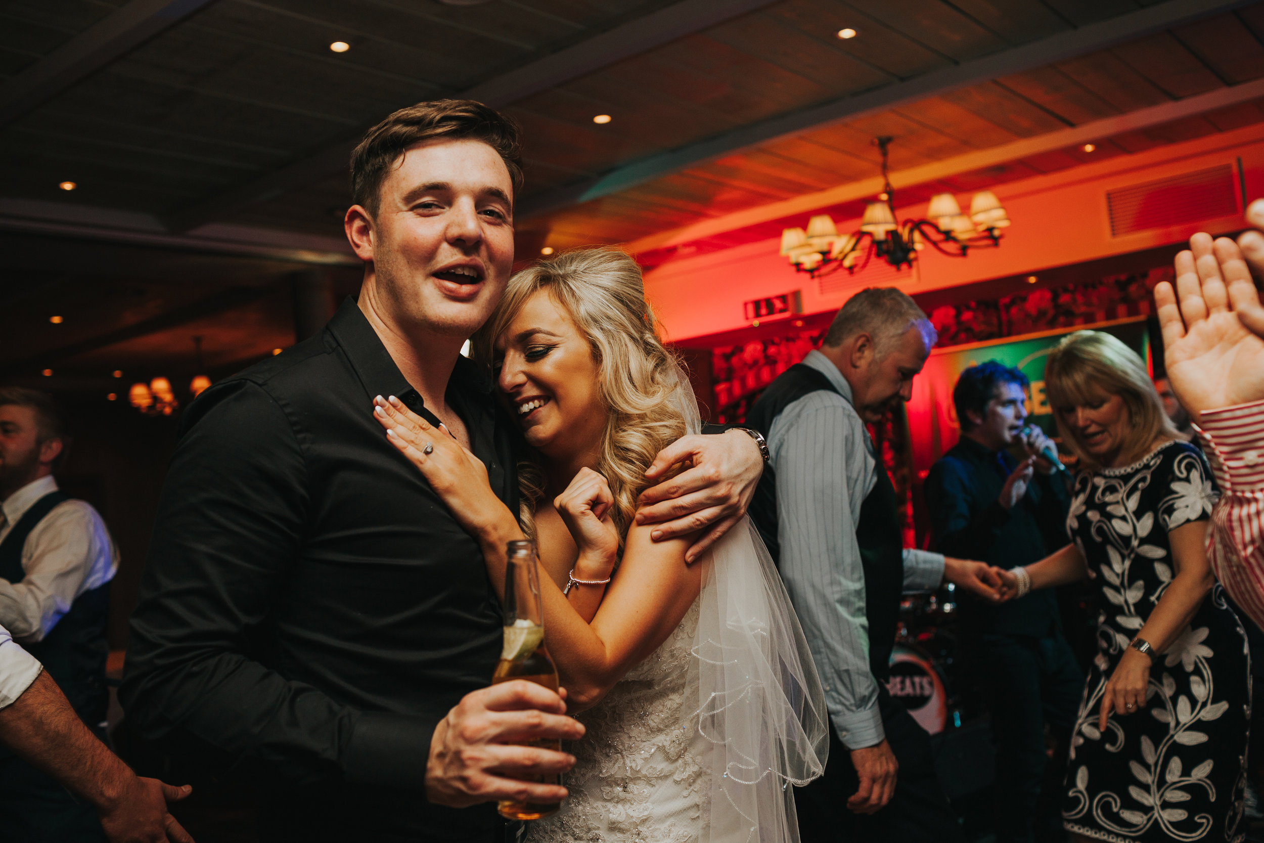 Bride hugs friend on dance floor of Stanley House. 