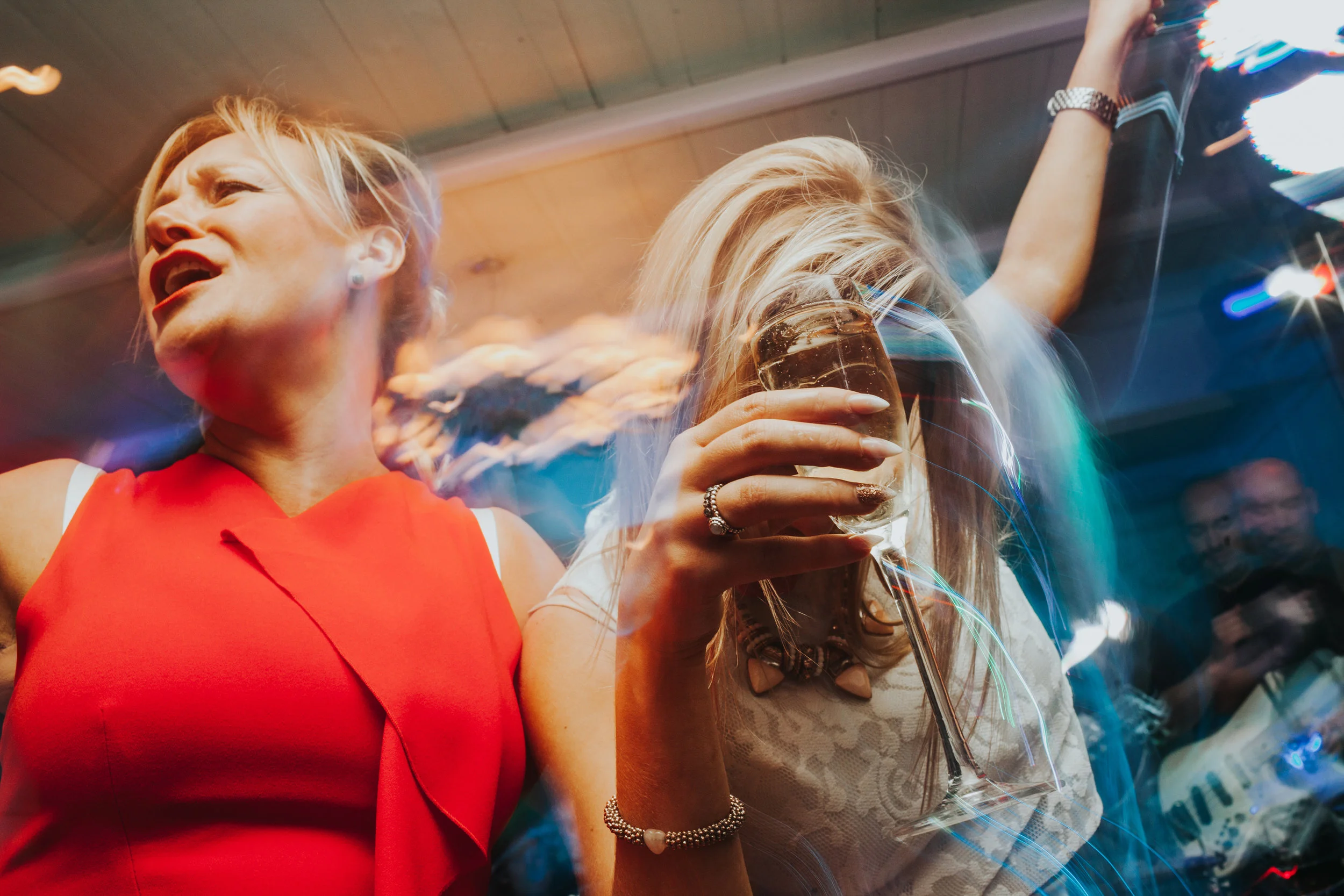 Guests dancing while holding champagne. 