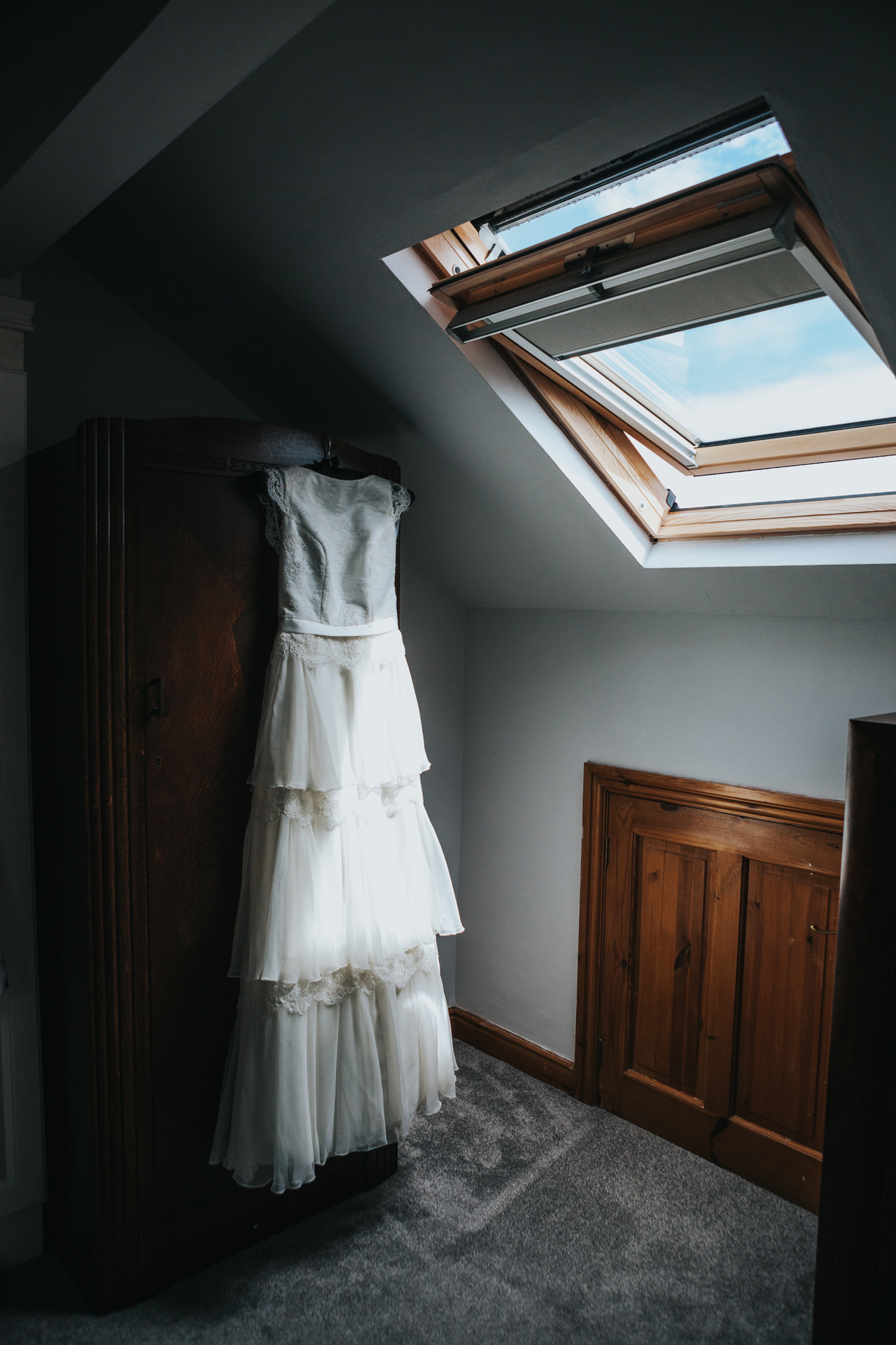 Brides dress hangs on wardrobe, Manchester. 