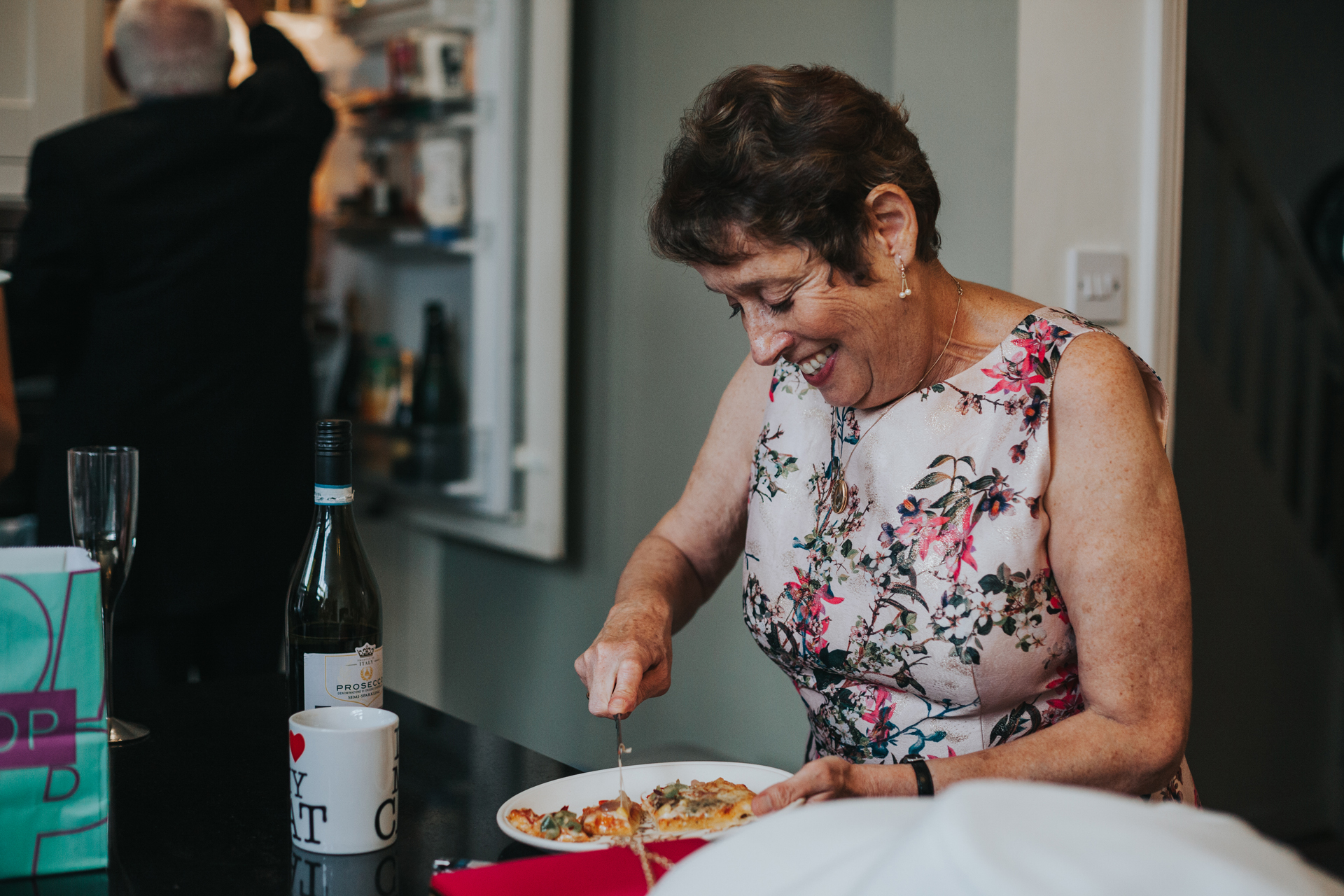 Mother of the bride cuts pizza for everyone. 