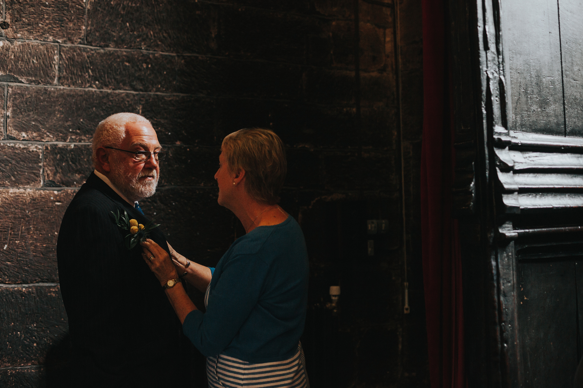 Father of the Bride has his tie fixed. 