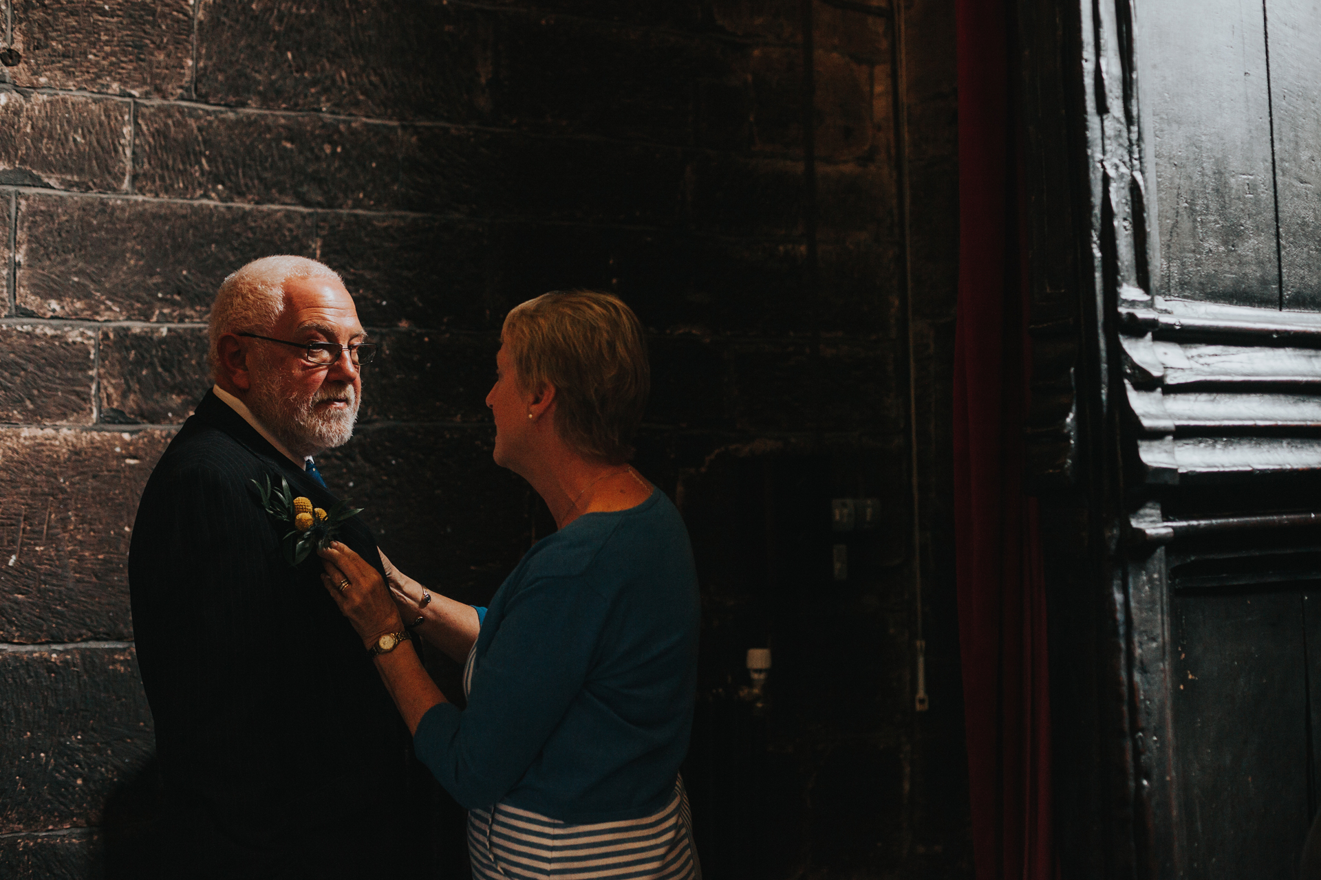 Father of the Bride has his tie fixed.