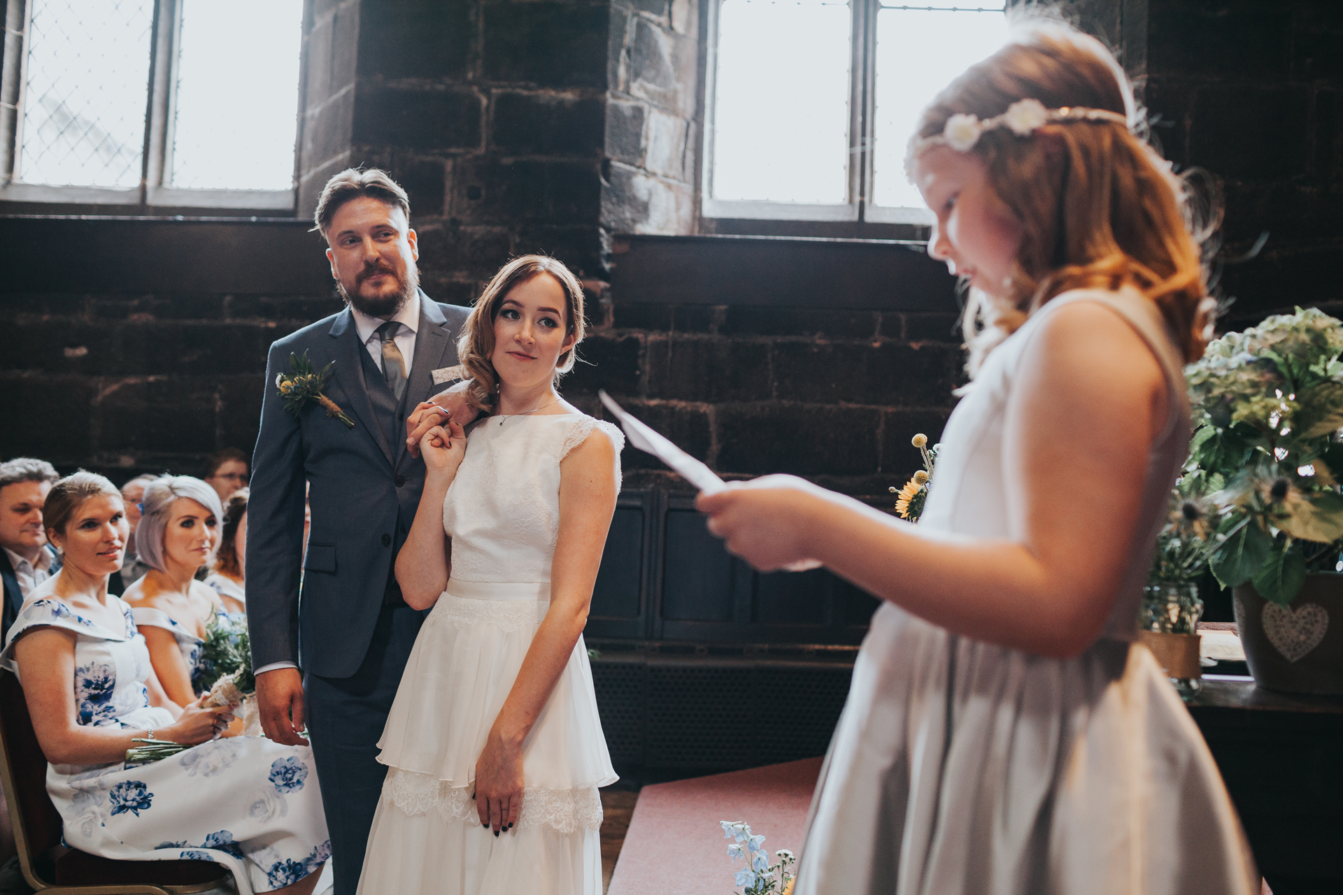 Bridesmaid reads and the Bride and the Groom look on.