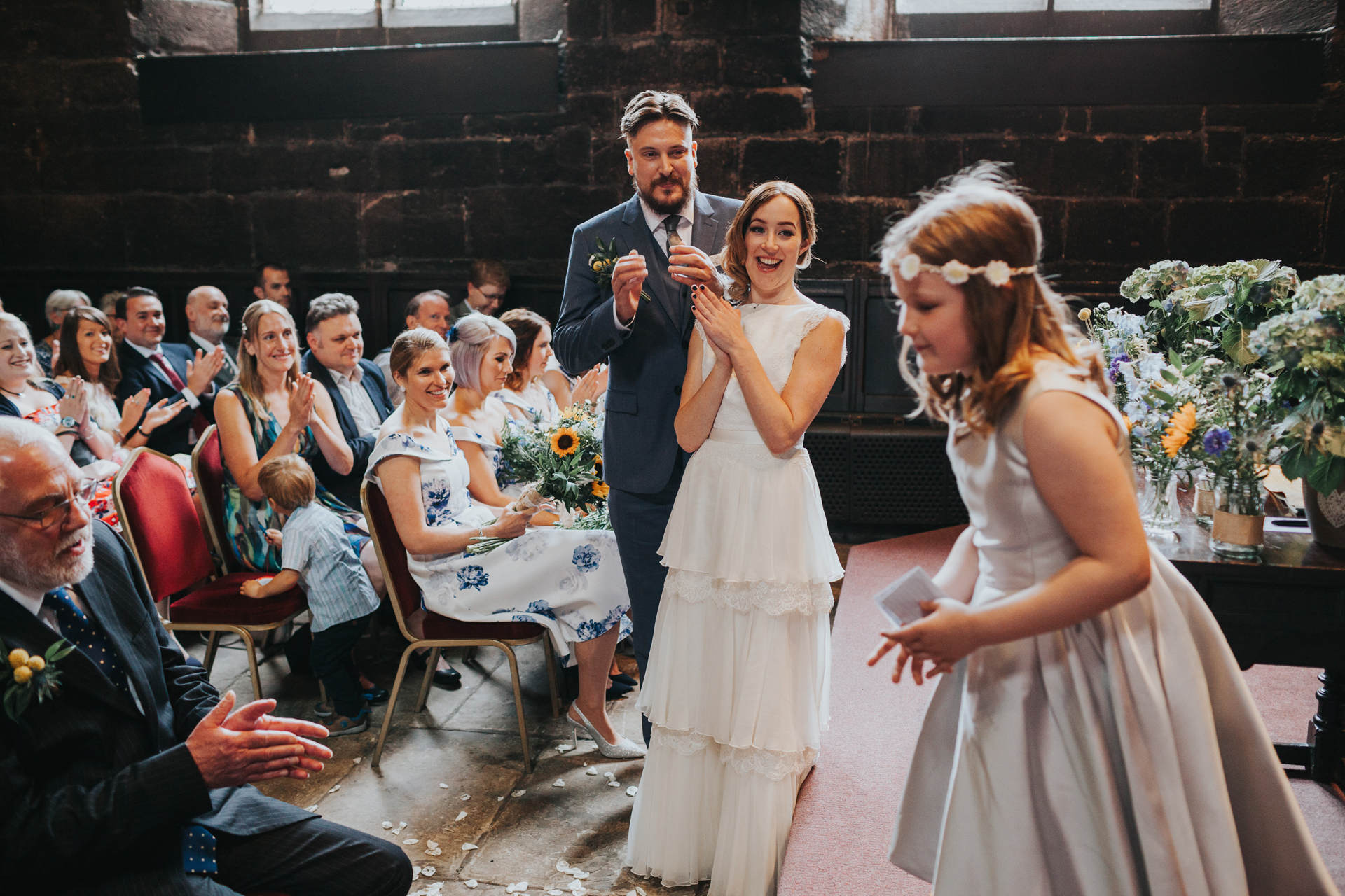 Bridesmaid jumps off the stage as the Bride and Groom clap. 