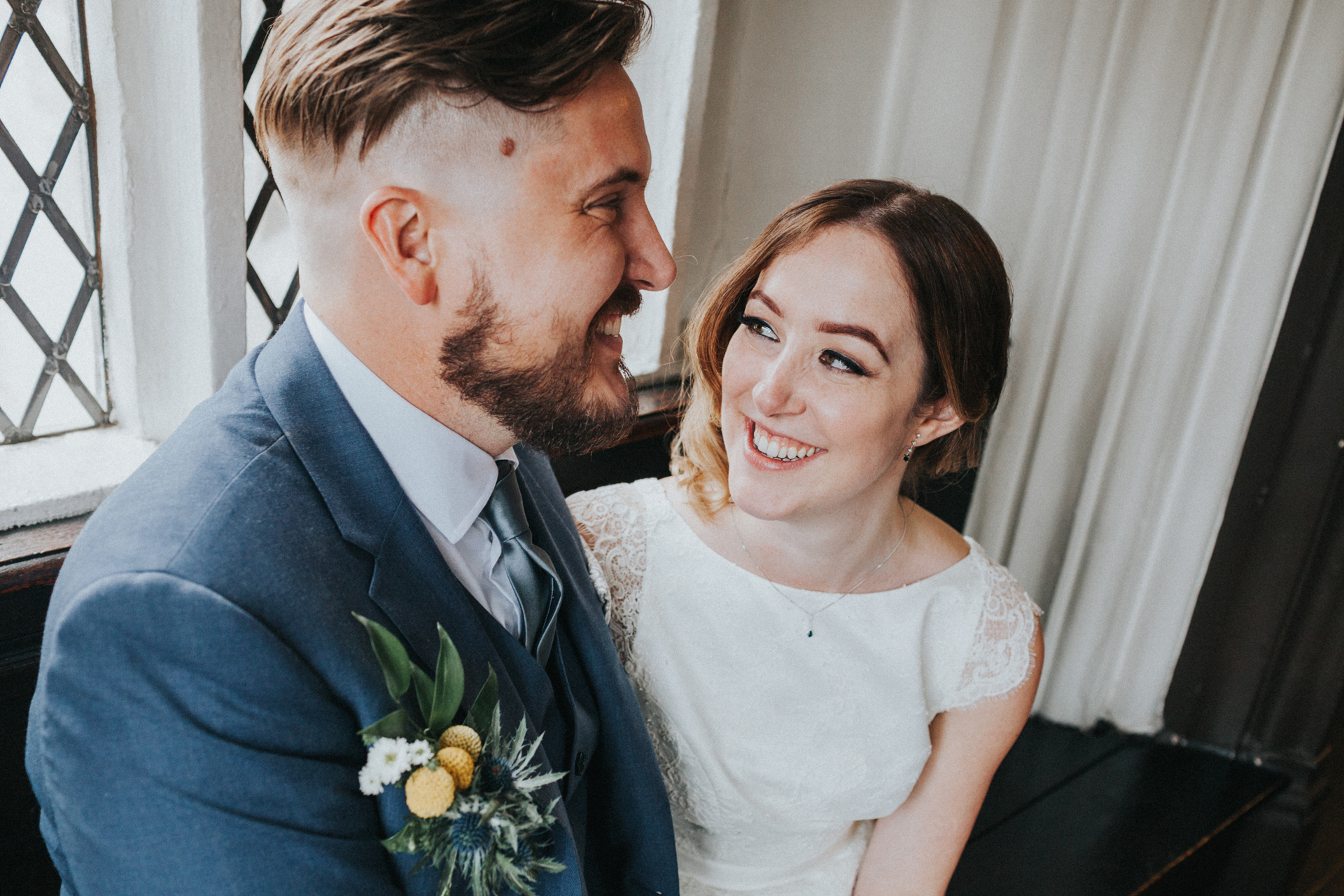 Bride and Groom laugh together at Chetham Library.