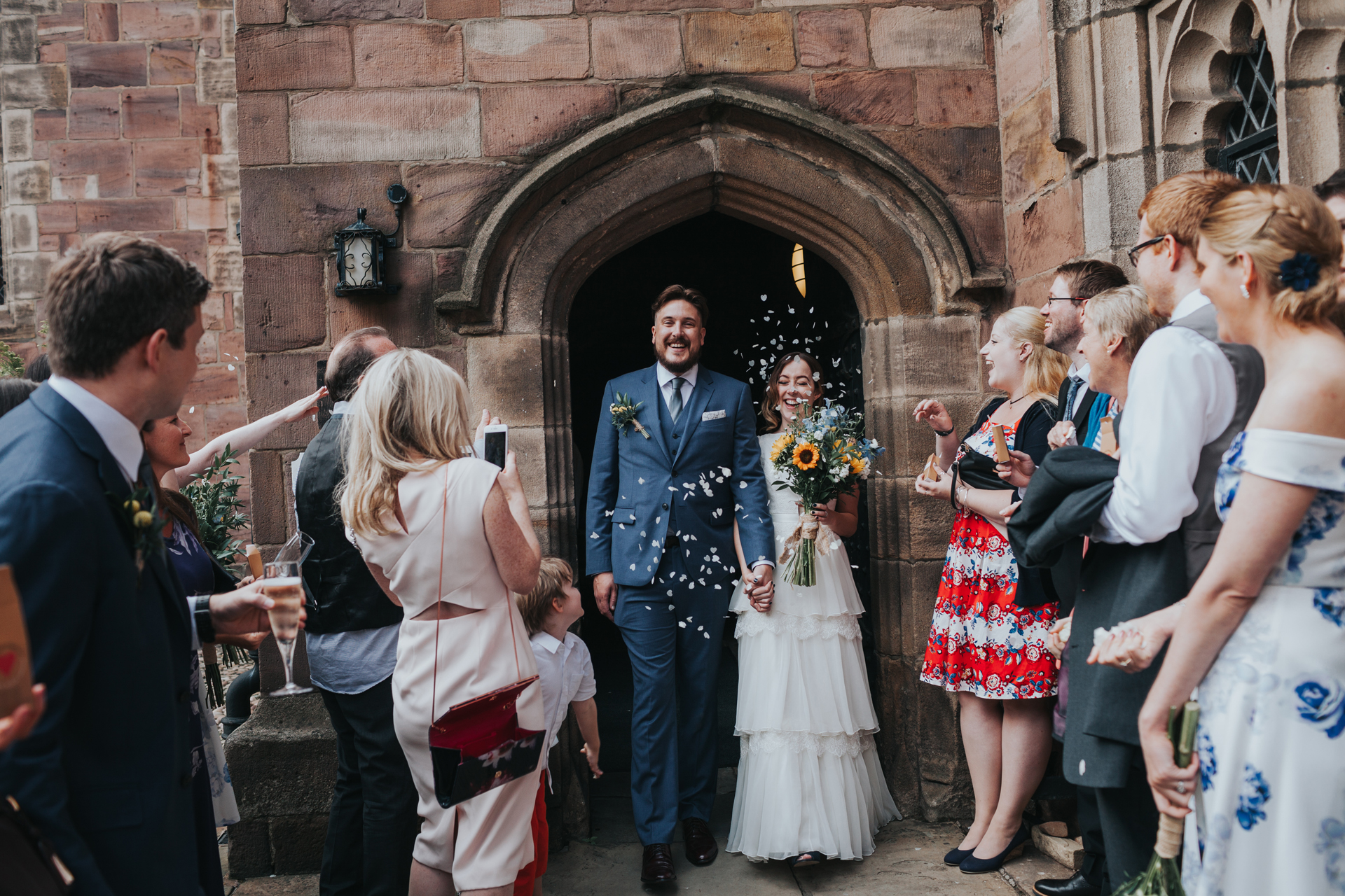 Bride and Groom exit Chetham Library to be greeting by wedding guests throwing confetti.