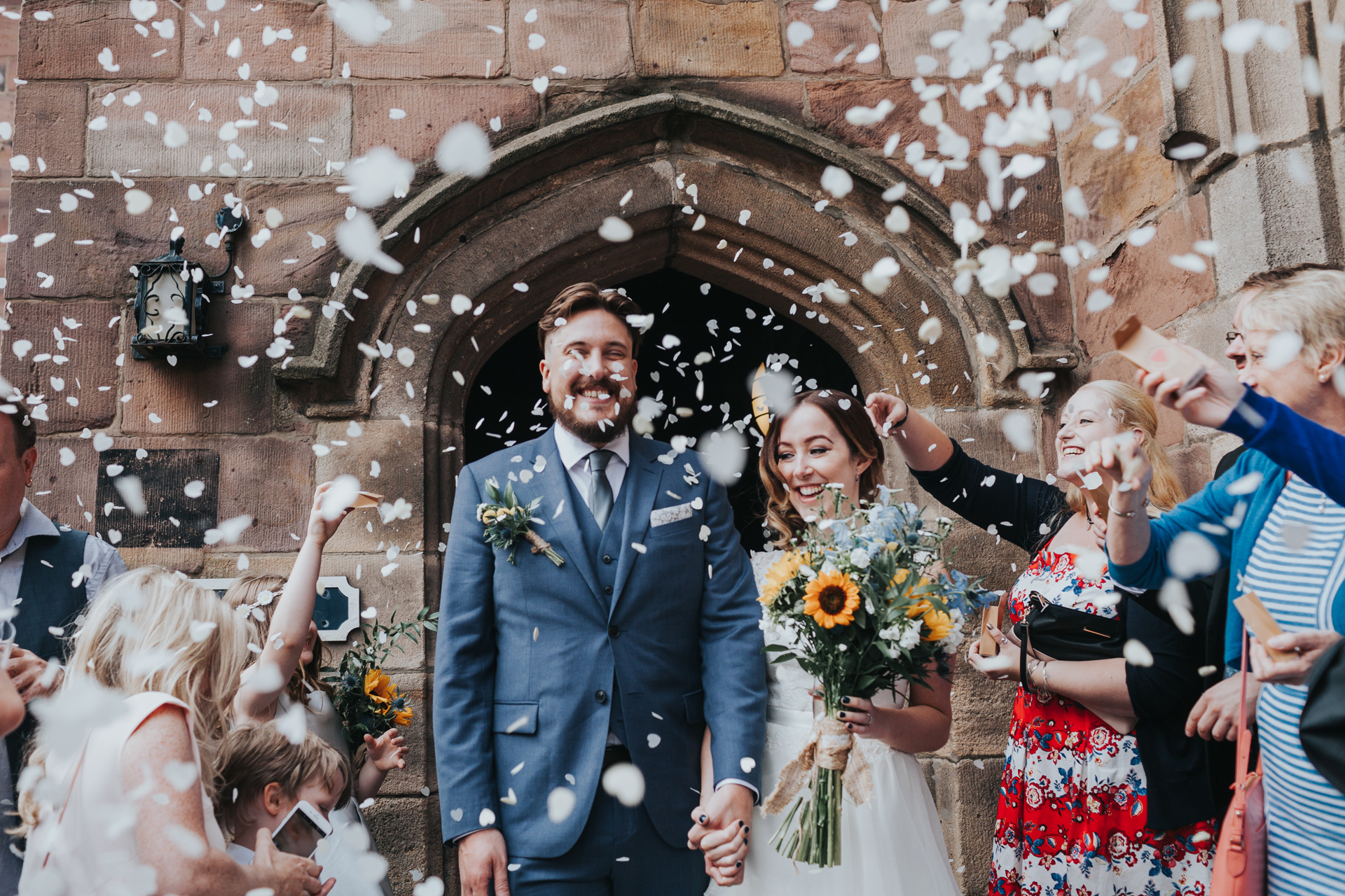 Bride and Groom have confetti thrown at them outside Chetham Library. 