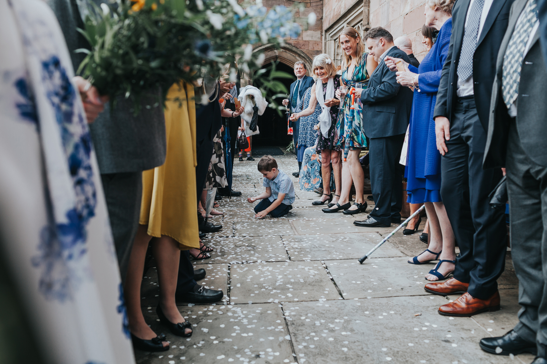 Little boy picks confetti up off the floor. 