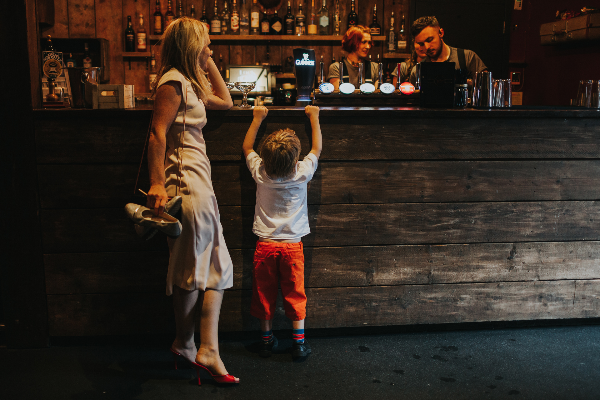 Toddler hangs of bar at wedding reception at Lock 91. 