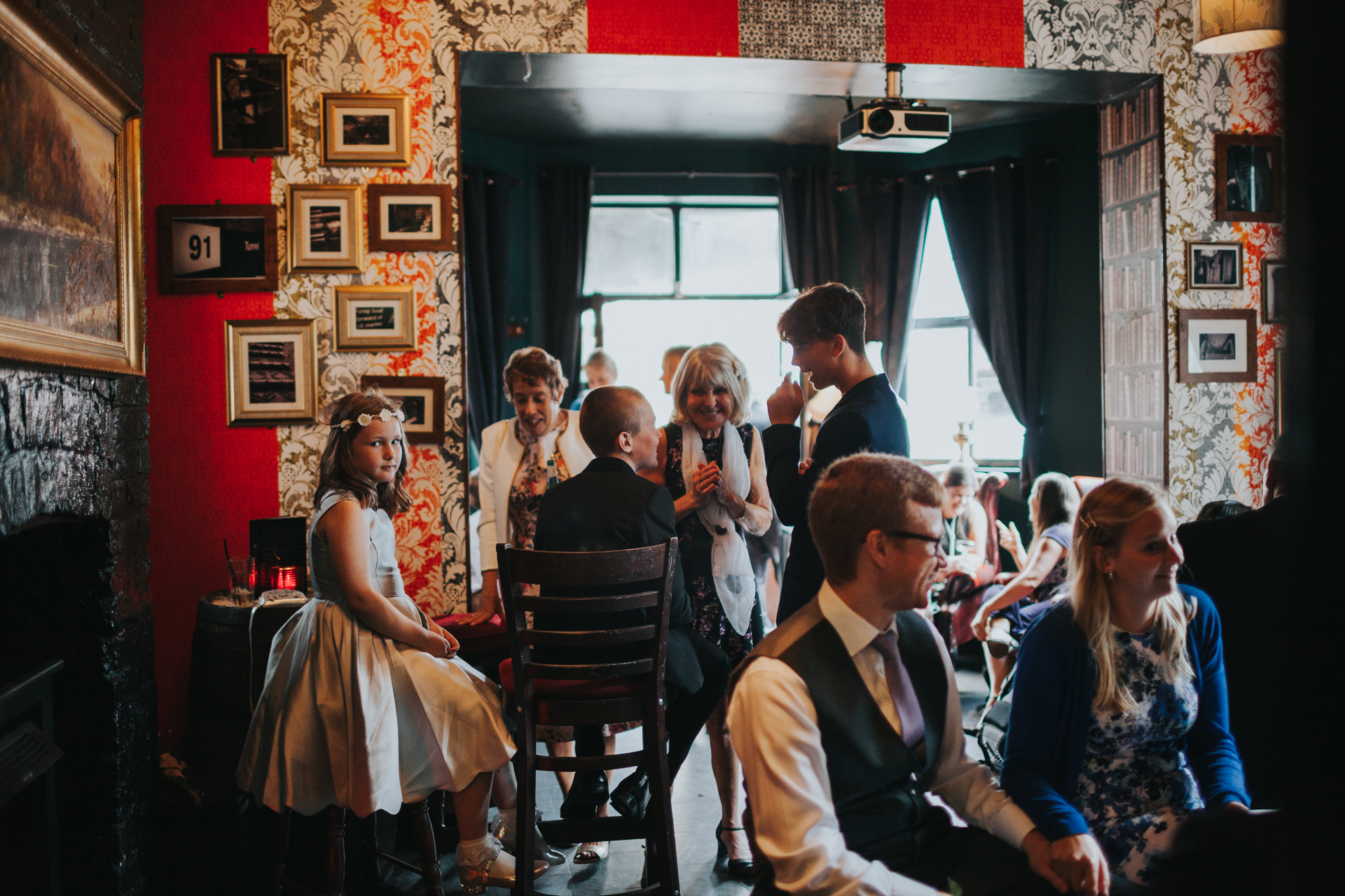 Bridesmaid sits in room full of people and is the only one to notice the camera at Lock 91 Wedding. 