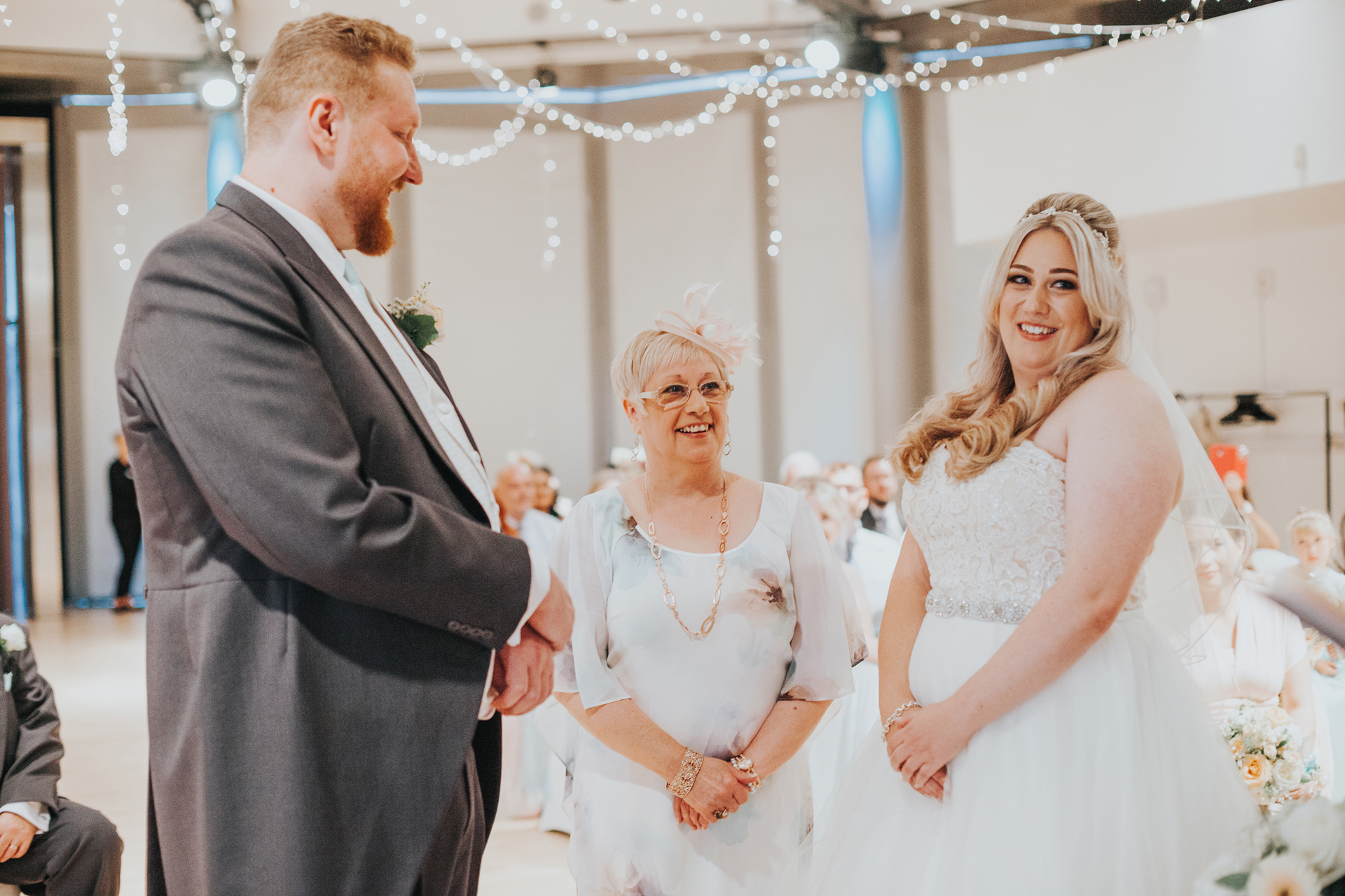 Bride and Groom Stand together as the mother of the bride gives her away. 