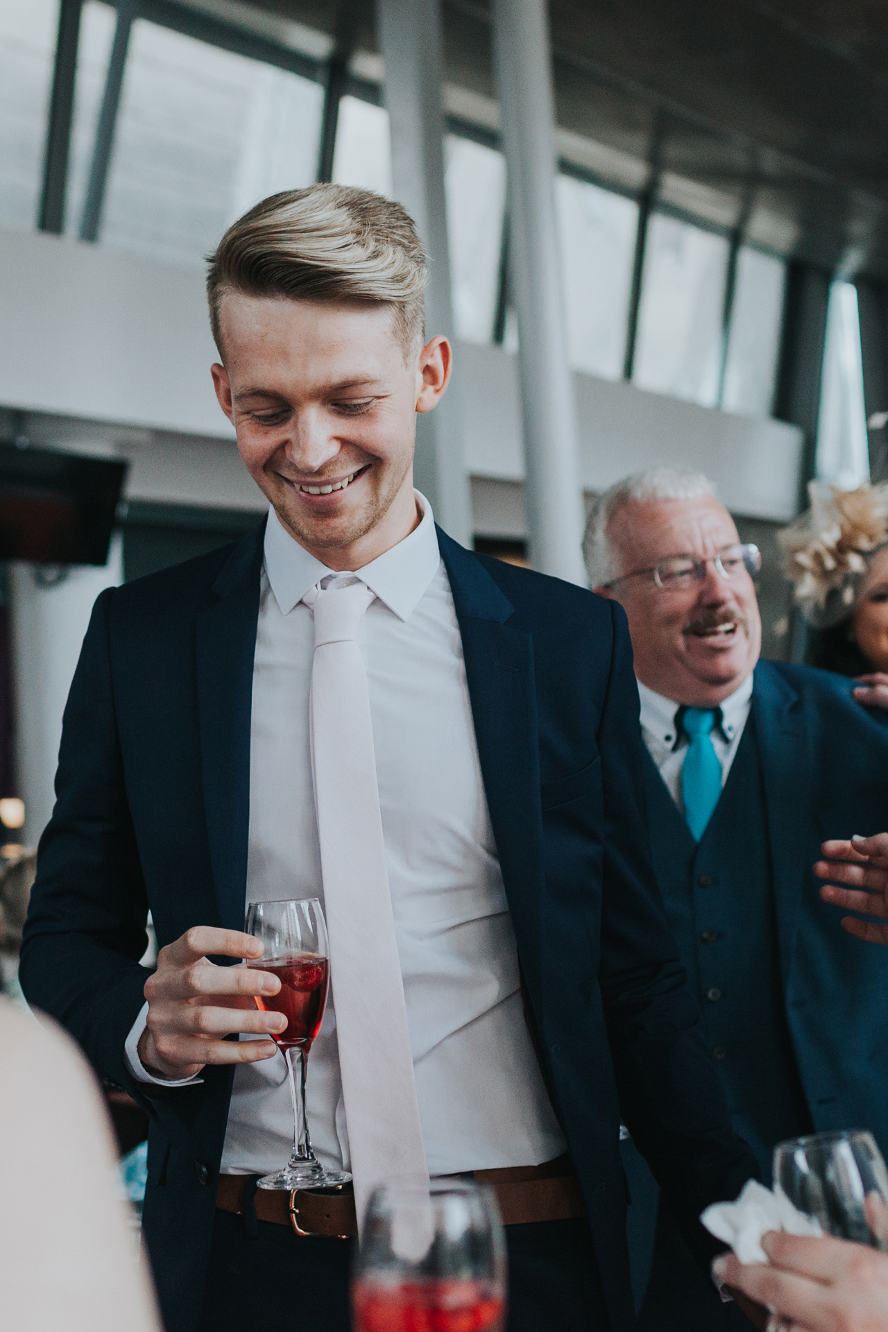 Young wedding guest looks pleased with himself. 