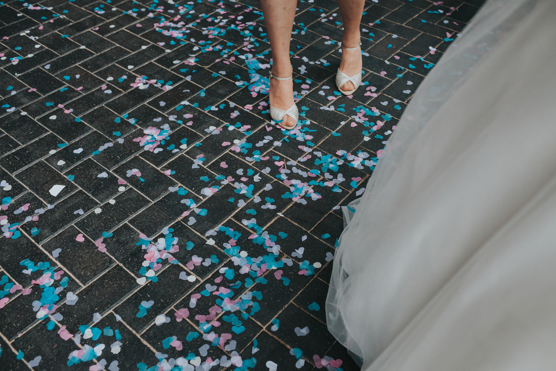 The floor is covered in pink and teal confetti. 