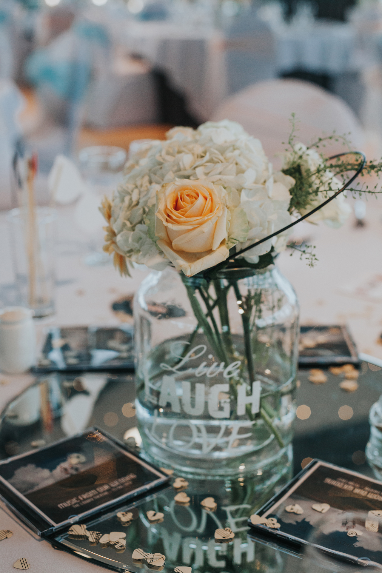 Roses in glass jars on the wedding table. 