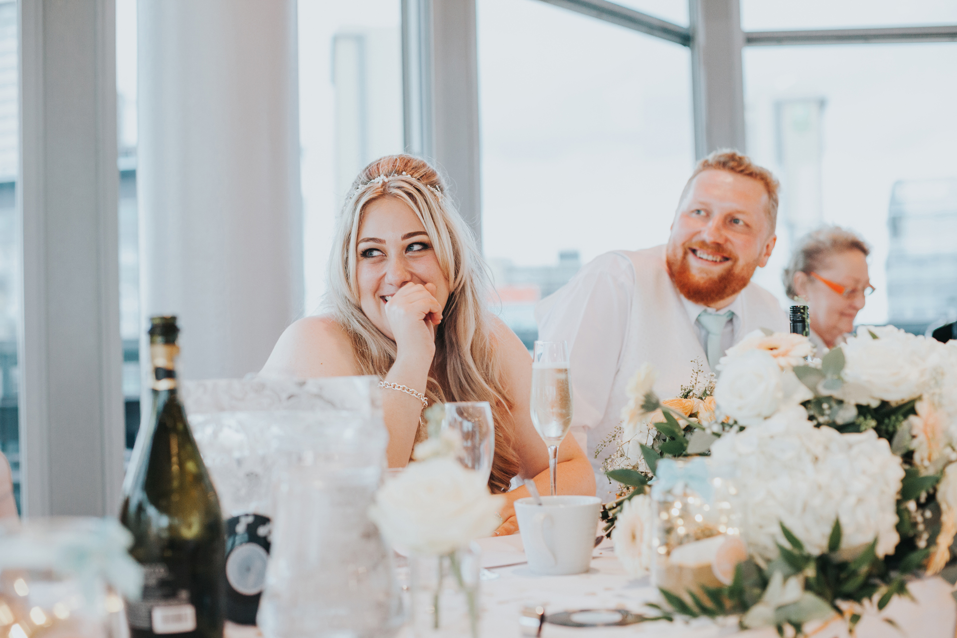 Bride laughs at her fathers speech. 