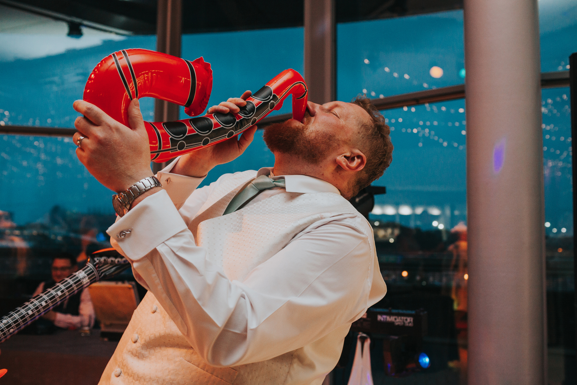 The Groom finds an inflatable saxophone. 